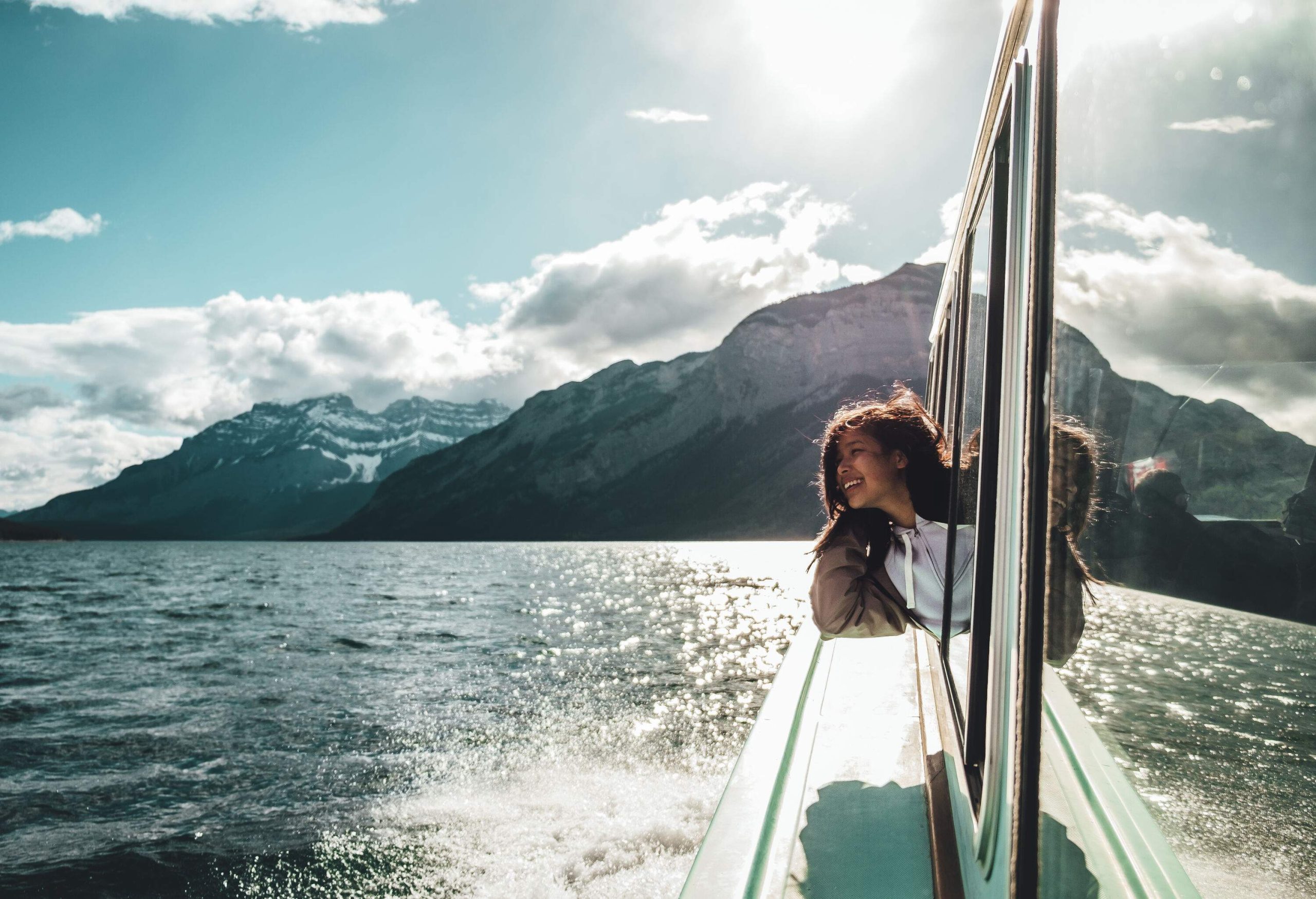 A lady traveller put her head out the window during a ferry ride.