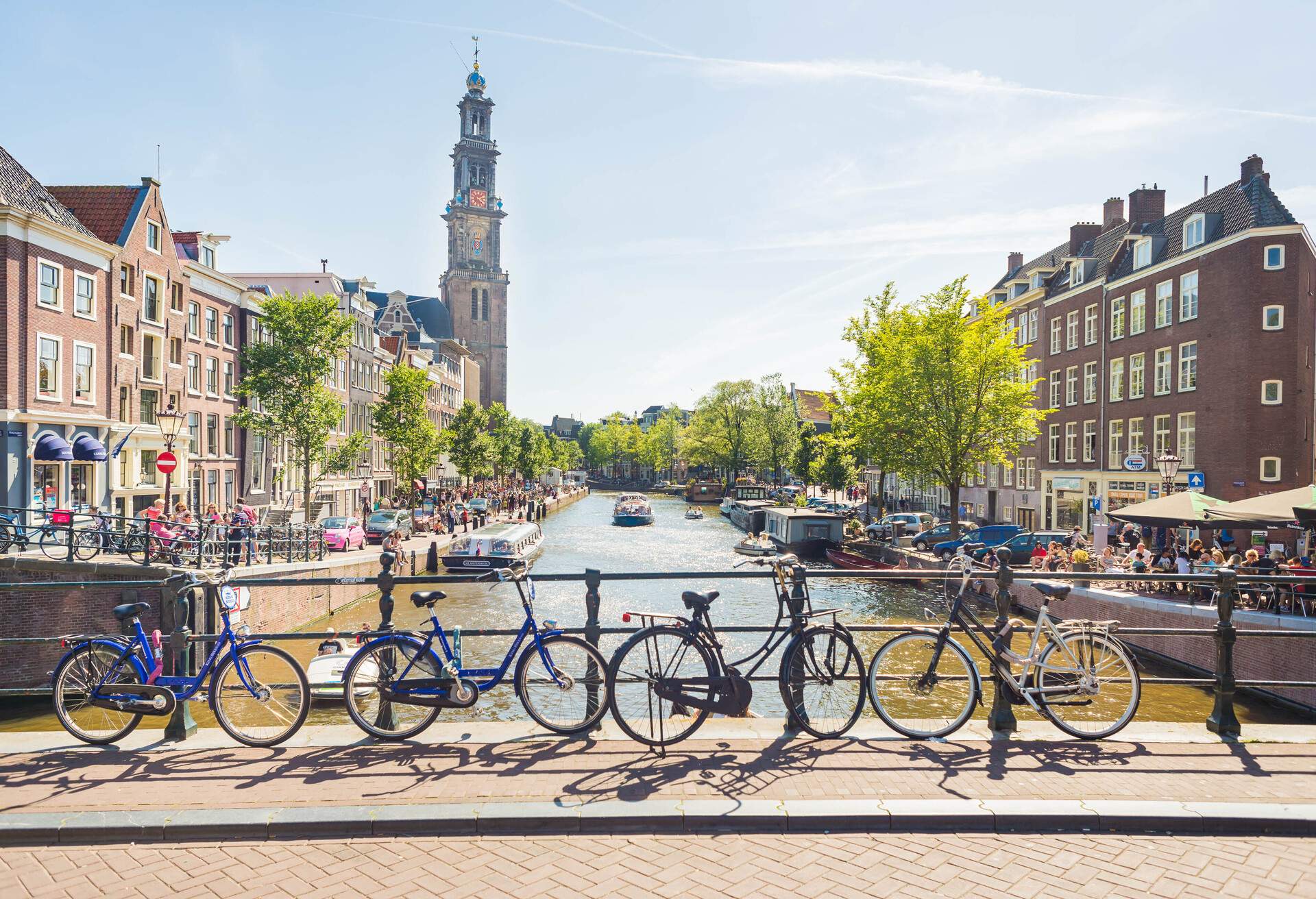 A view over one of the many canals in Amsterdam. Bicycles, canals, boats and the Westerkerk in the back, making this photo completely and typical Amsterdam.