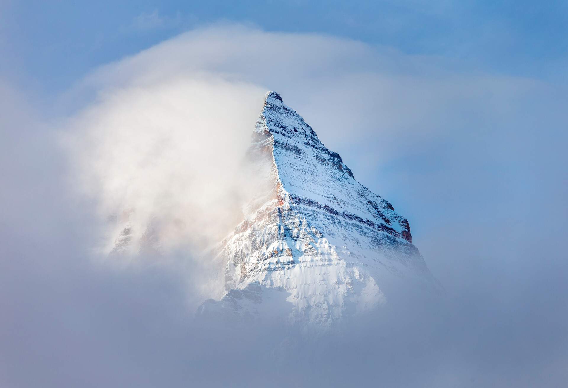 Pyramid shaped Mount Assiniboine in the fog.