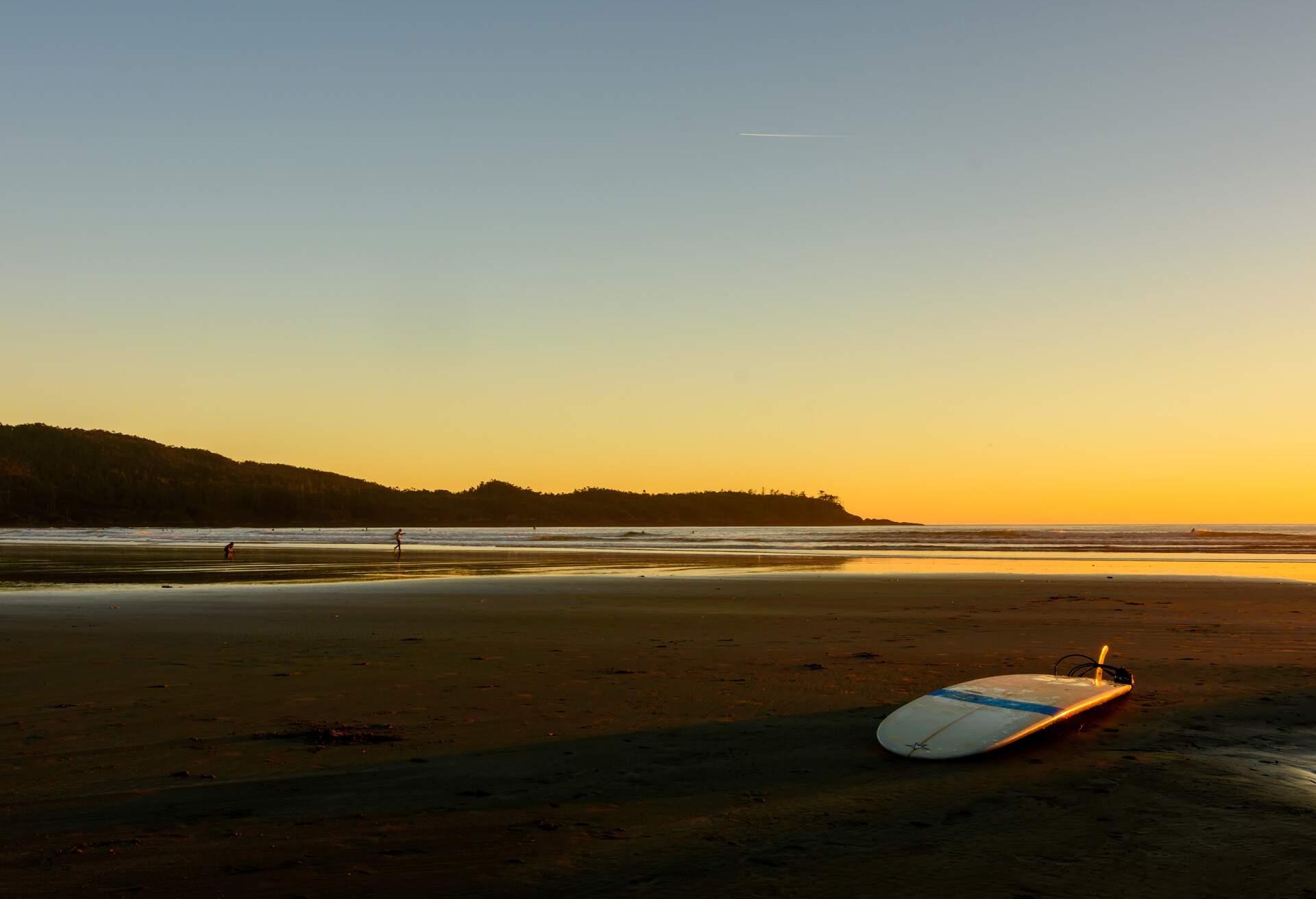 A surfboard is located on a beach on Vancouver Island