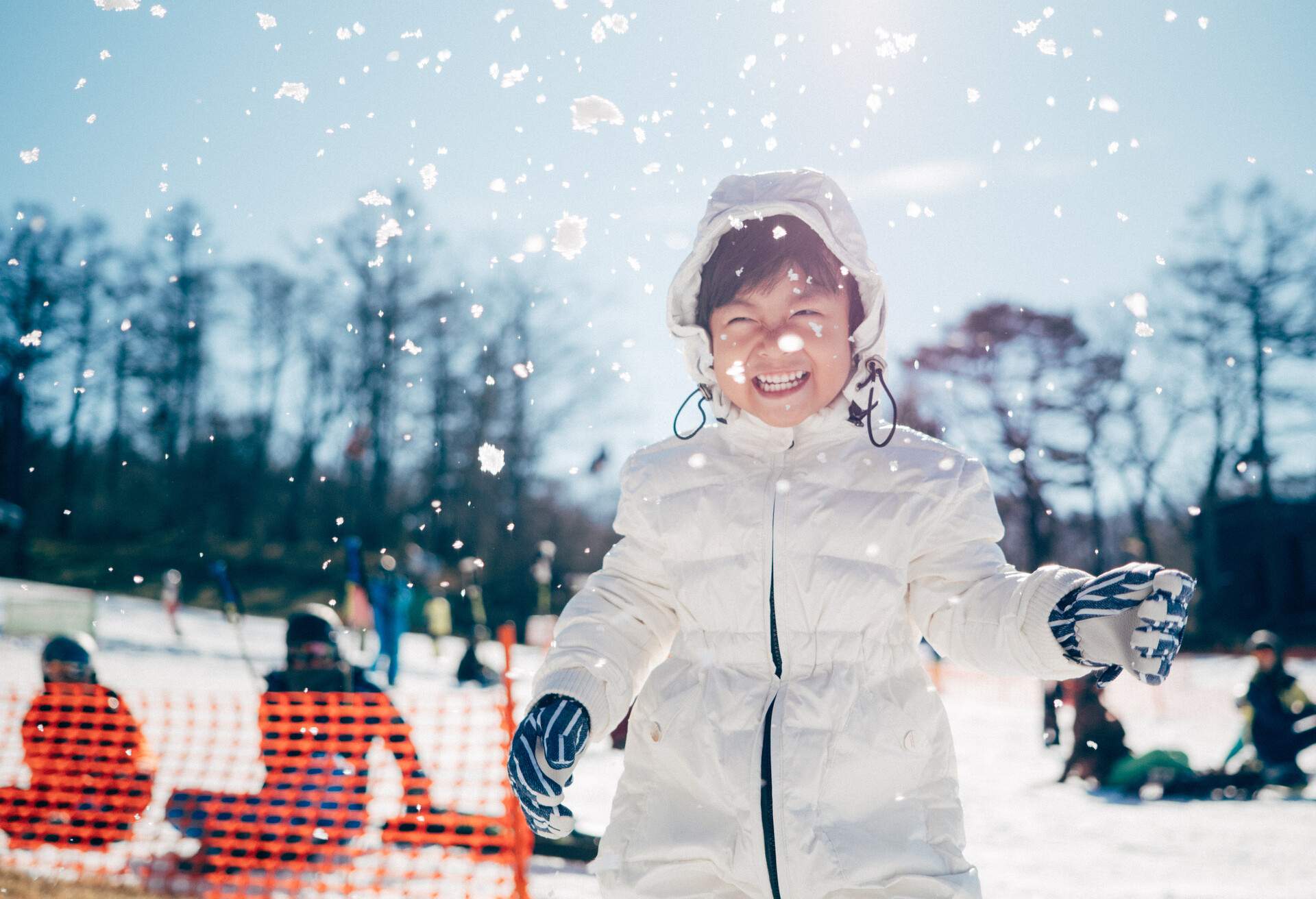 Happy asian kid having fun with snow in winter day in Hokkaido. Japan.
