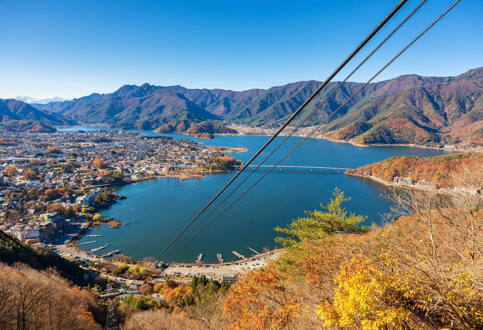 Seaside town with turquoise lake and autumn mountains in the background.