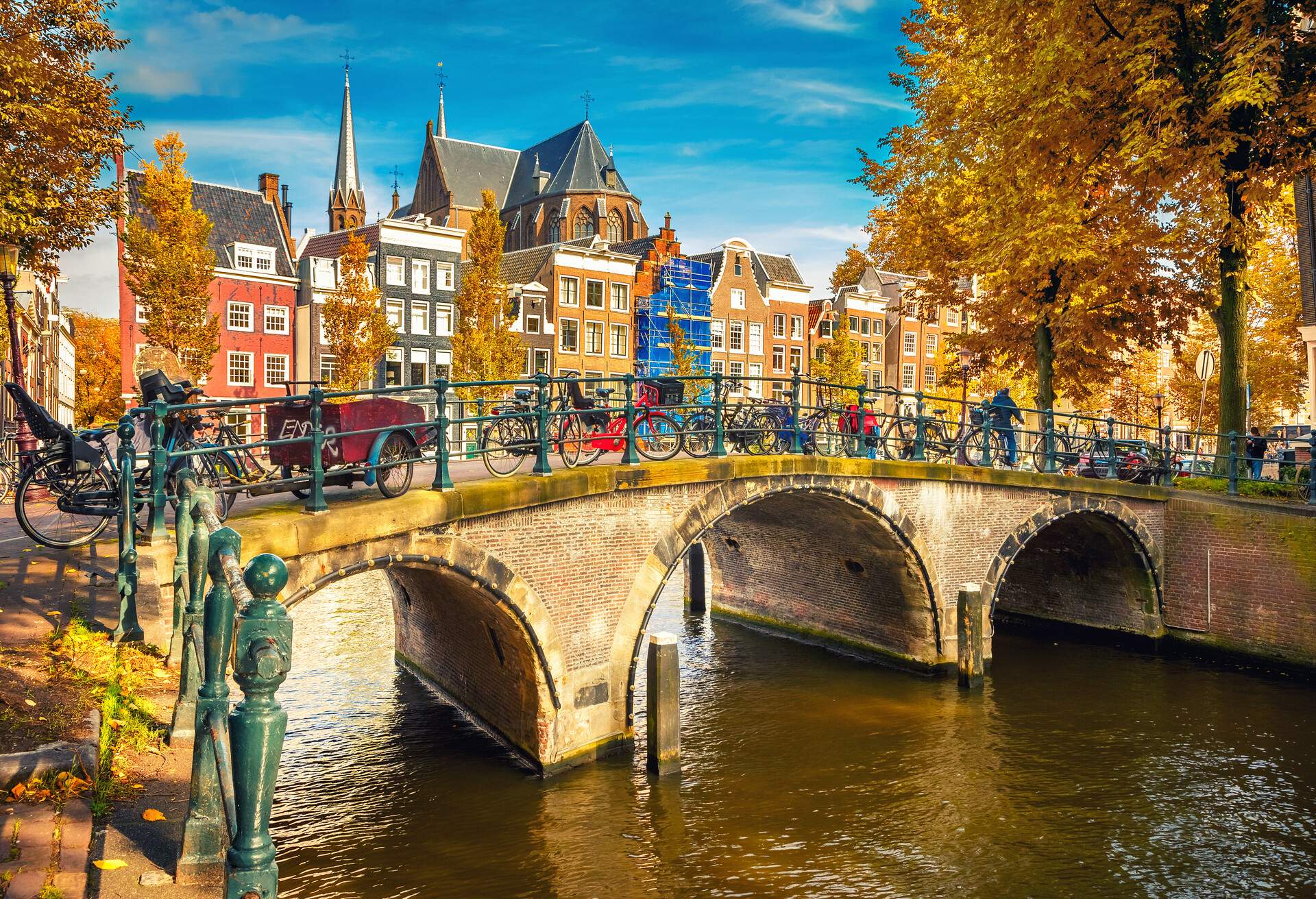 Canal bridges with bicycles on the railings and vibrant neighbouring buildings in the background.