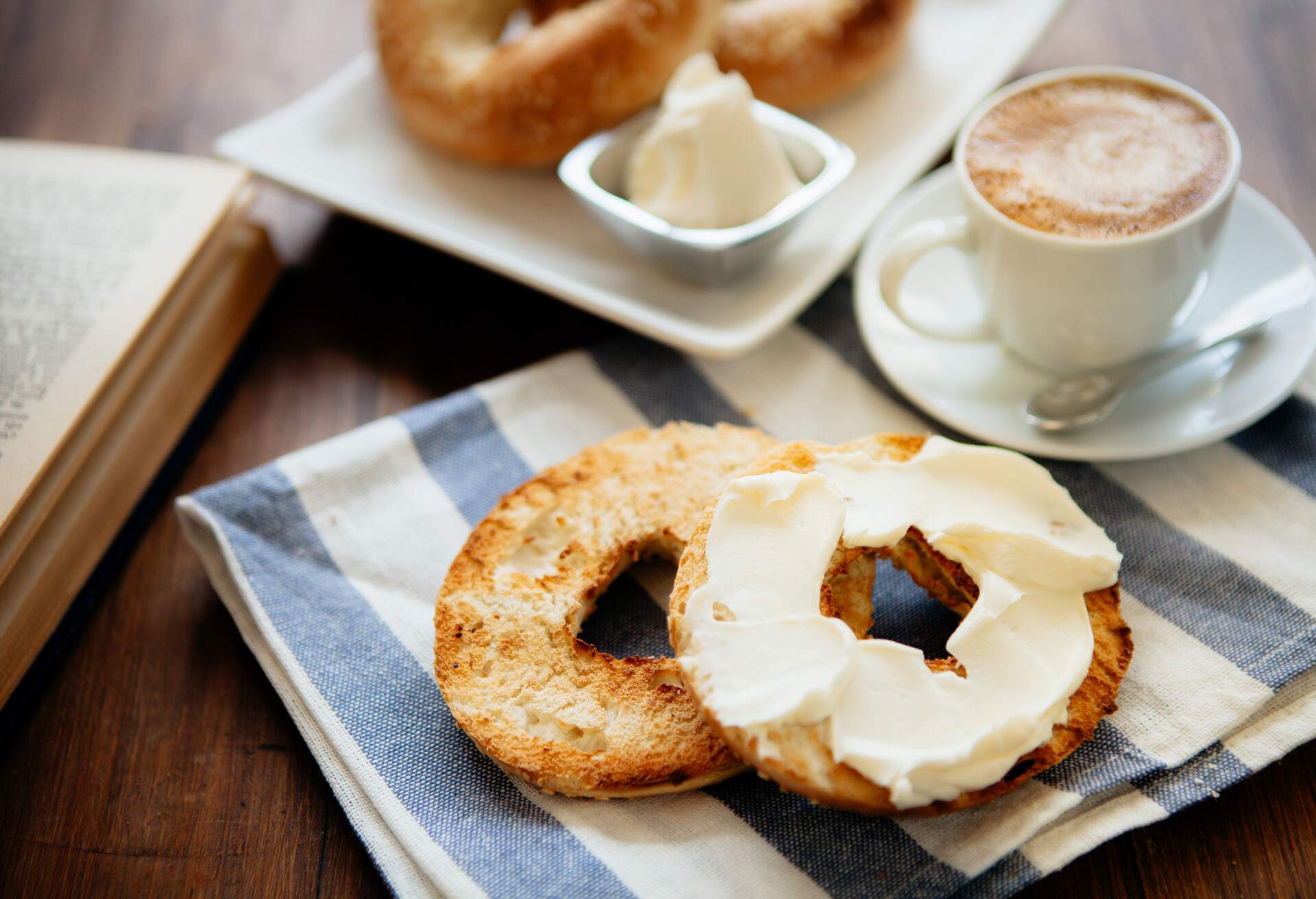 Montreal style bagels on a plate with cream cheese and coffee