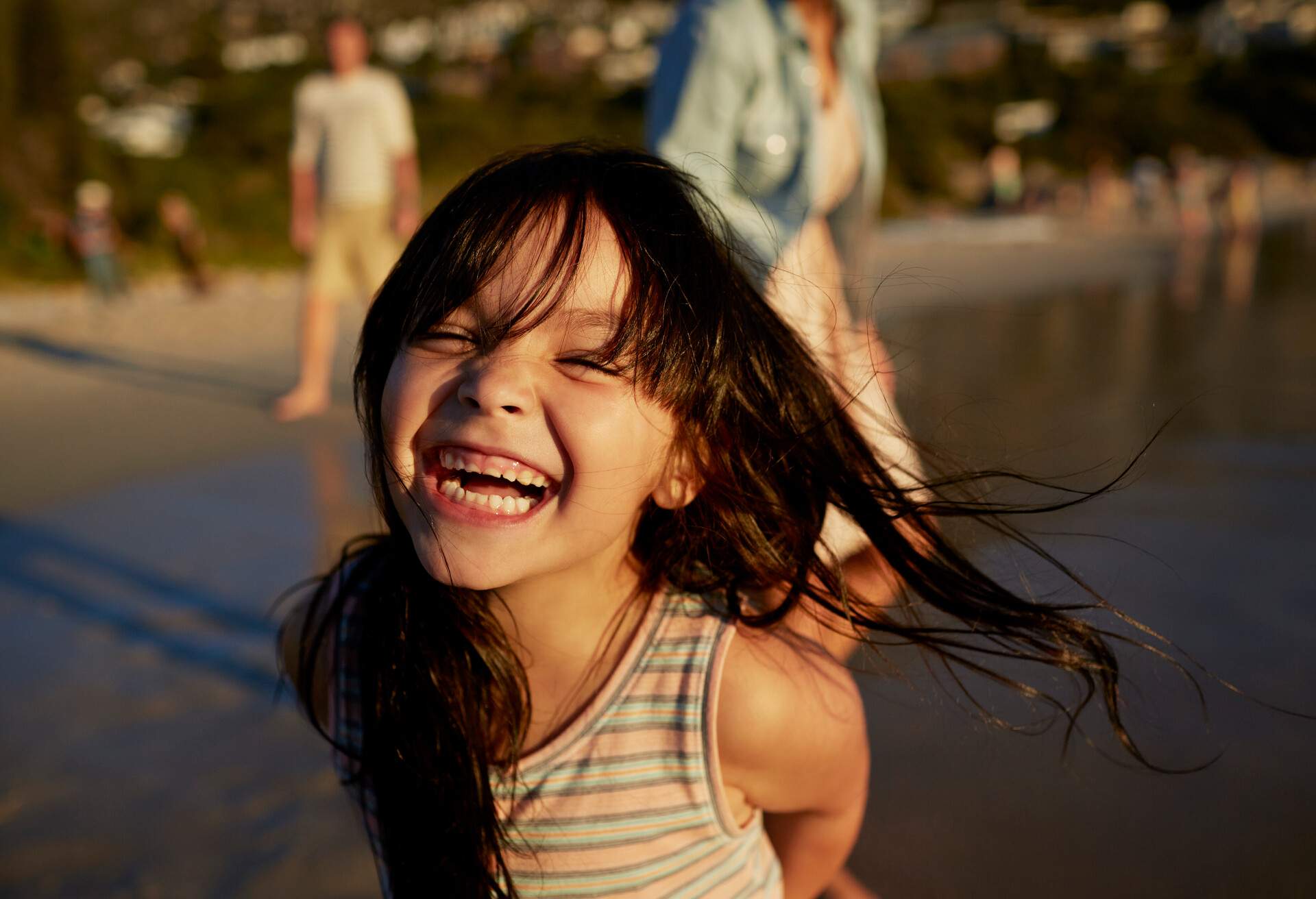 Cute girl standing on beach and laughing