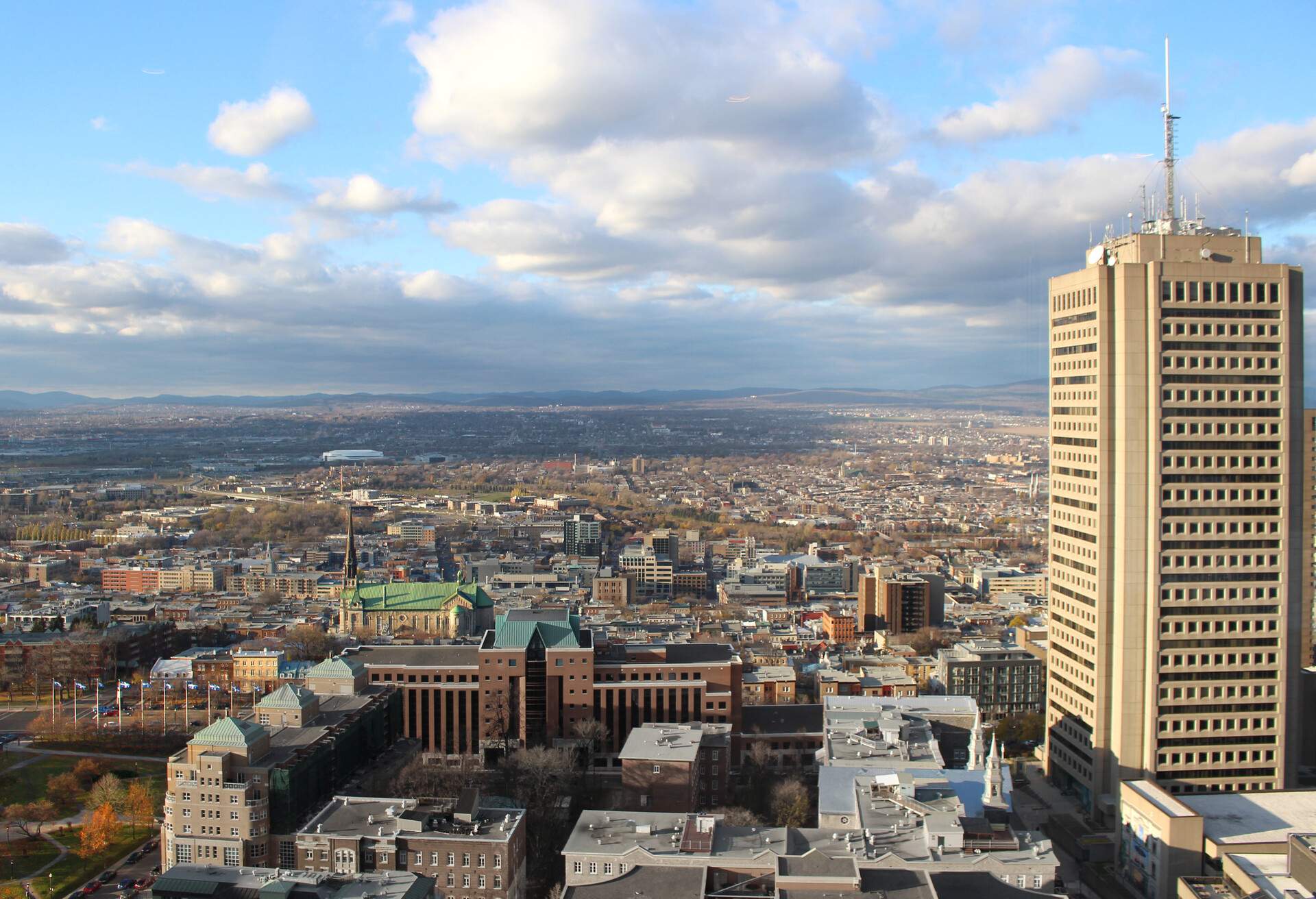 View looking north in Quebec City, Canada, toward the Édifice Marie-Guyart. Previously known as Complexe G, this 31-storey brutalist skyscraper is the tallest building in the city, and the tallest building in Canada east of Montreal. Situated on Parliament Hill, the building houses government offices and the Observatoire de la Capitale observation deck. In the background are Saint-Jean-Baptiste Catholic Church and the Videotron Centre arena, inaugurated in 2015.