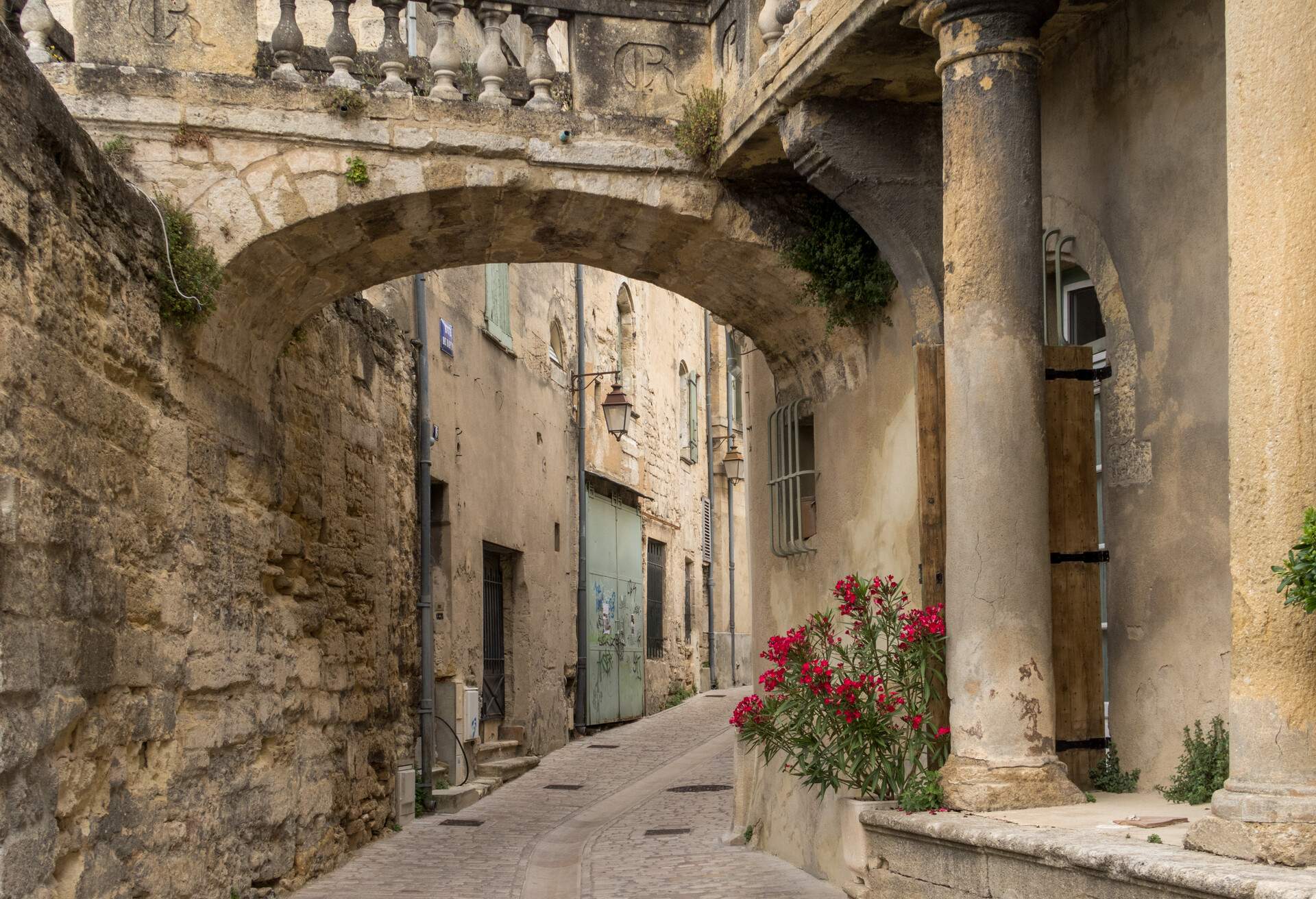 Old street with arch in the town of Uzès, region Gard, France