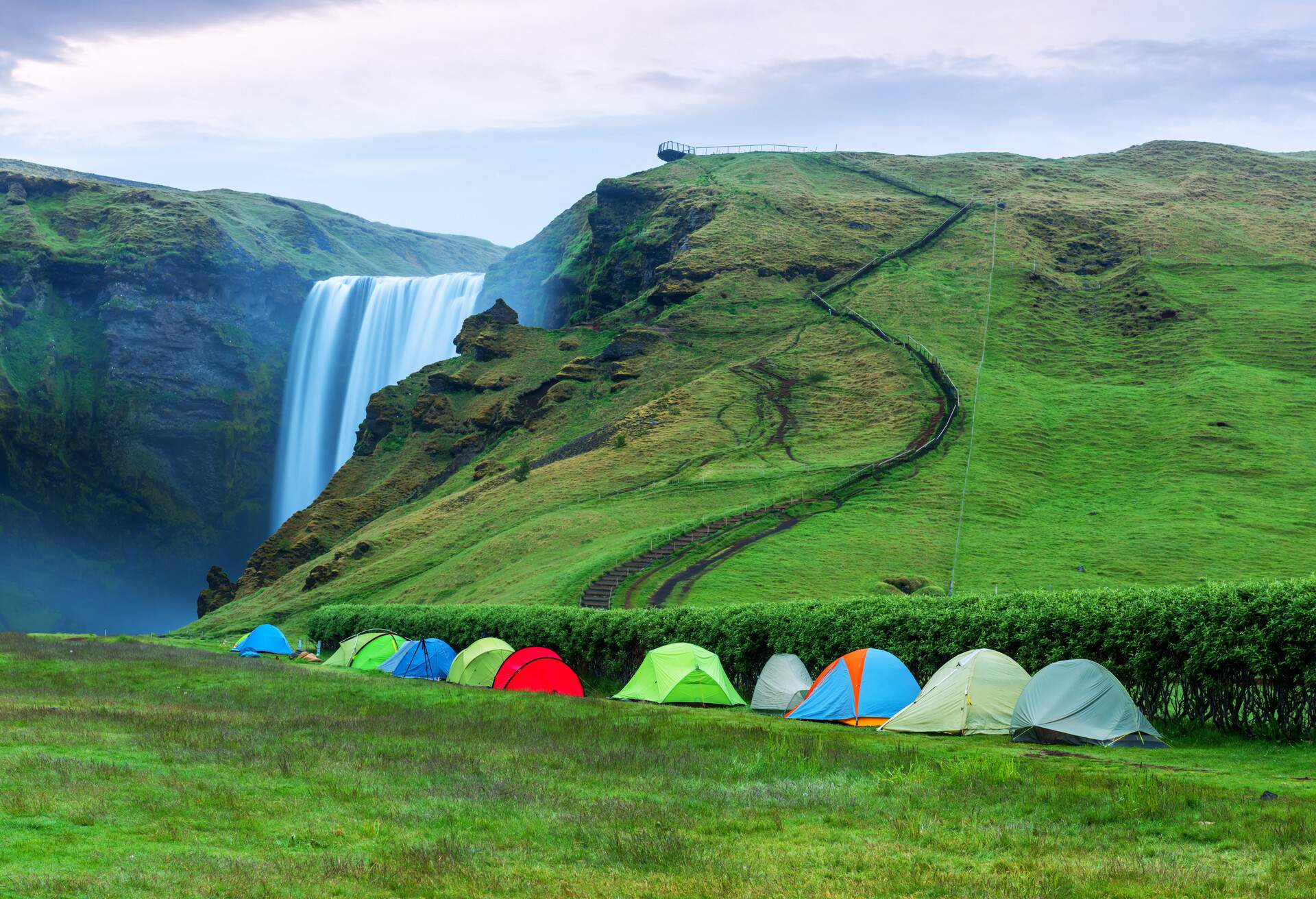 Camping tents near the famous Skogafoss waterfall on Skoga river. Iceland, Europe