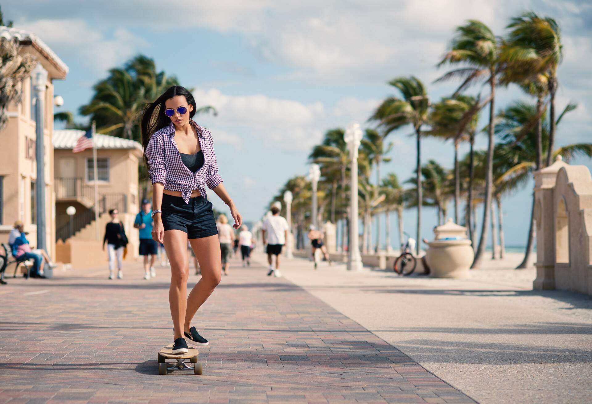 Sporty young woman riding long board on Hollywood beach in Miami, Florida