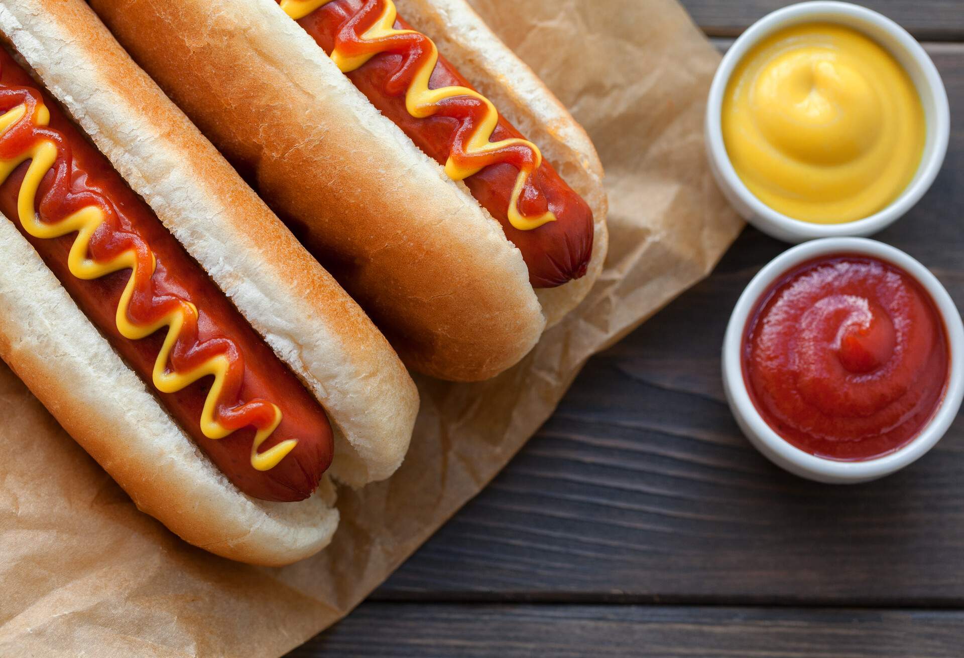 Barbecue Grilled Hot Dog with Yellow Mustard and ketchup on wooden table