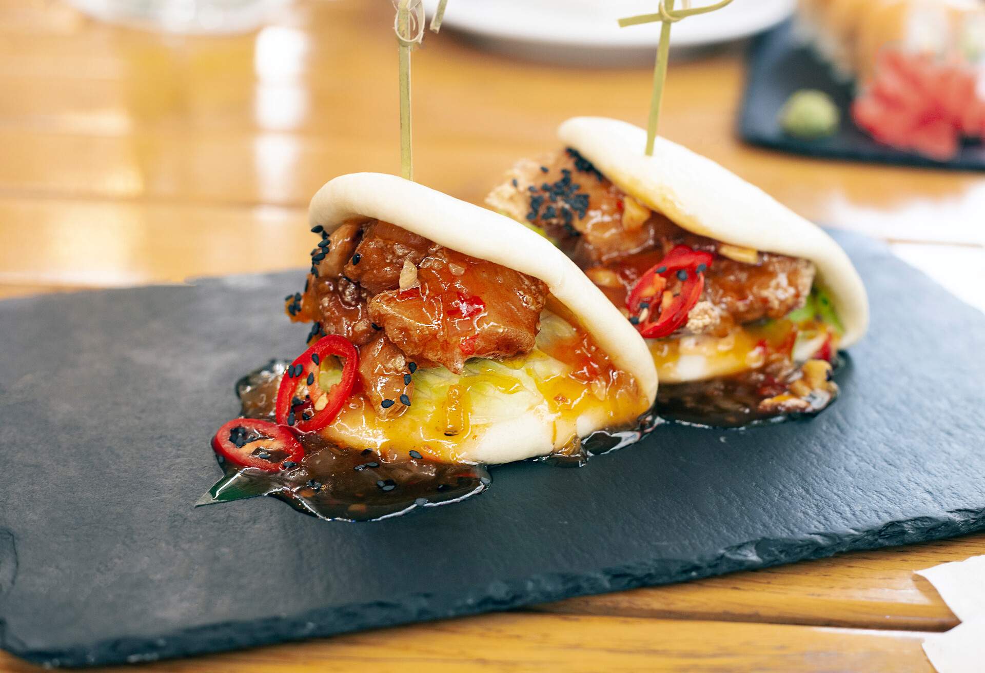 Asian traditional meal: bao with chicken and chili pepper on restaurant table