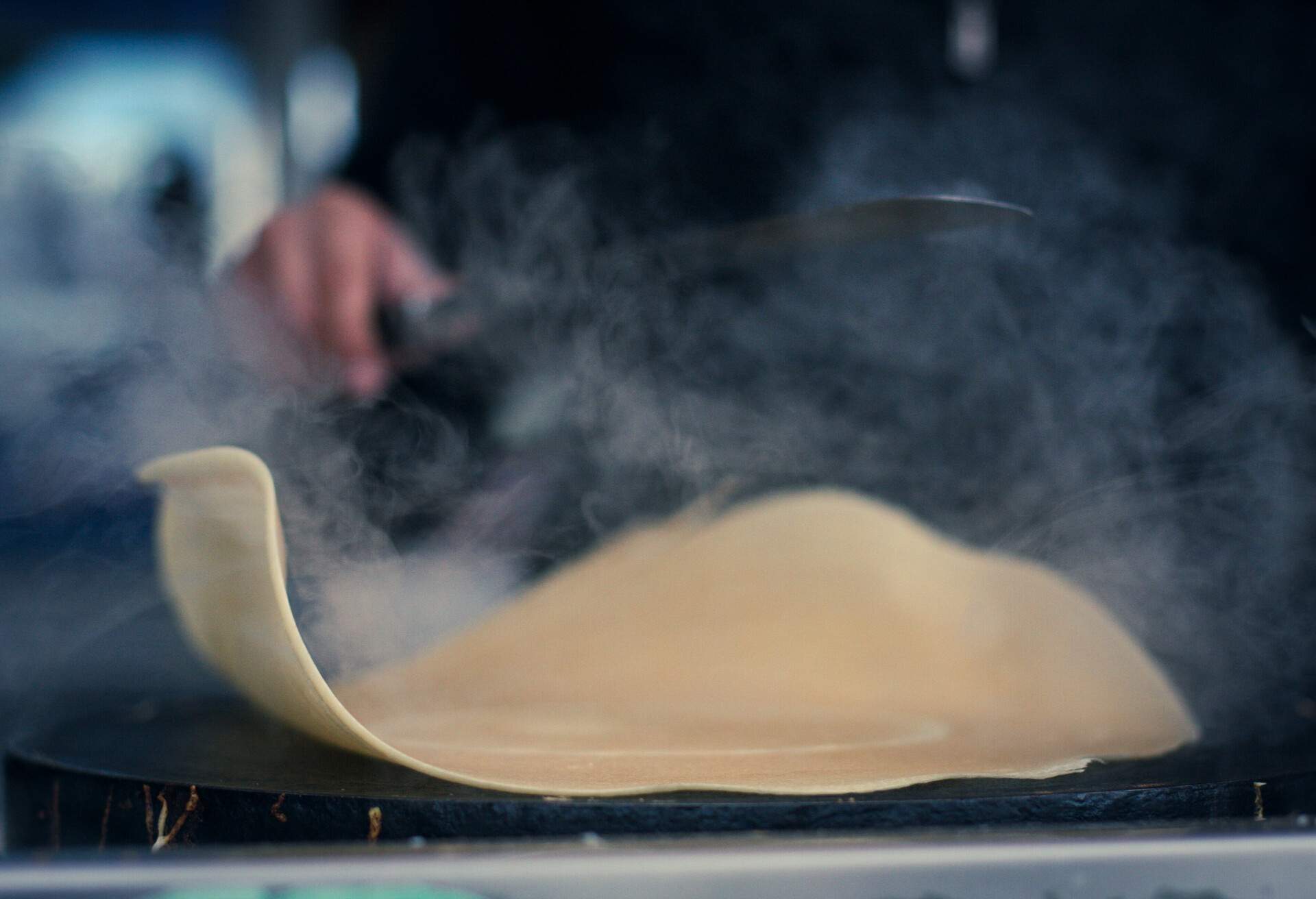 steaming while making crepes outside of the eiffel tower in Paris, France.