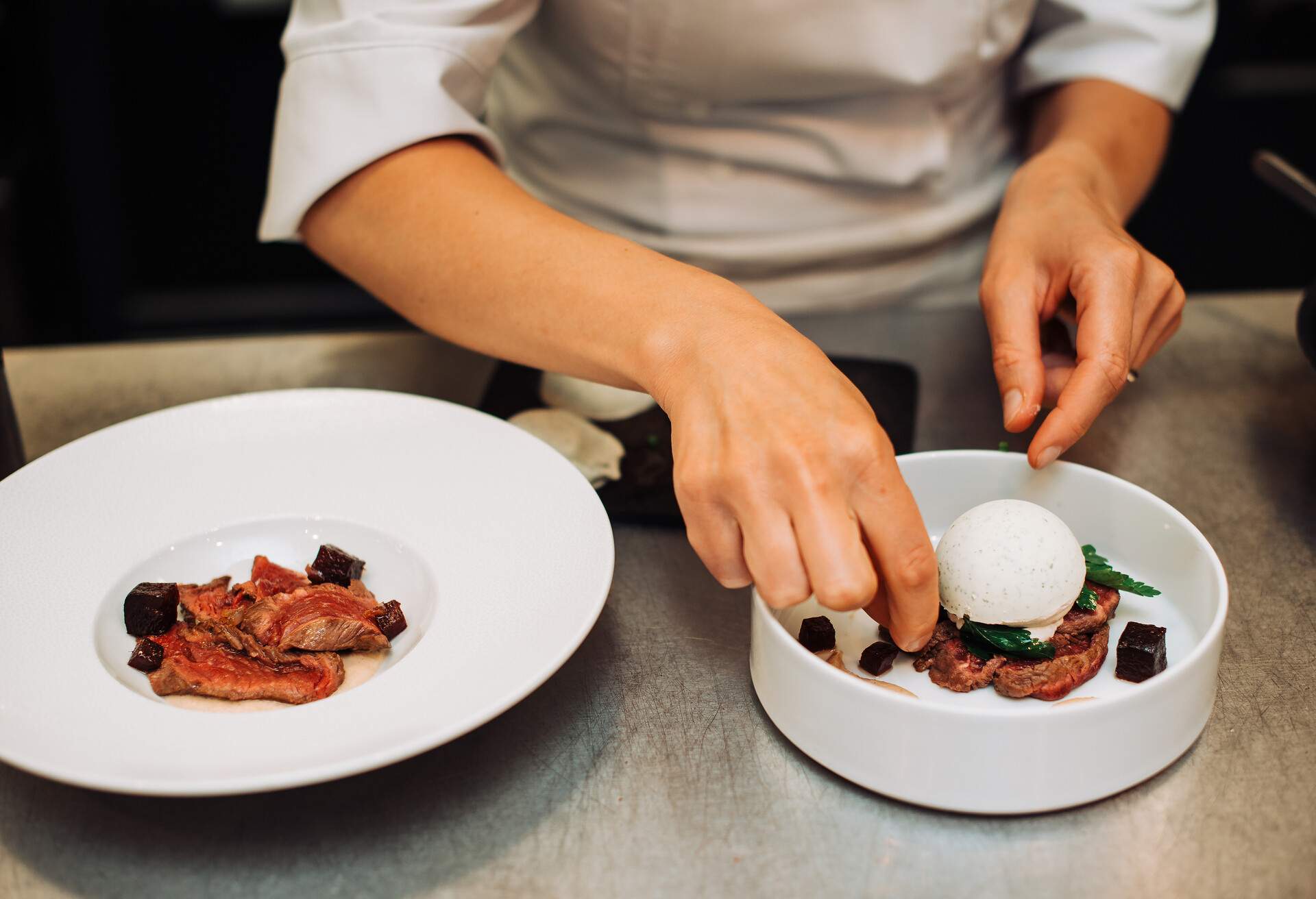 Michelin chef serving food for guests in the kitchen, french cuisine, close up, crop on hands 