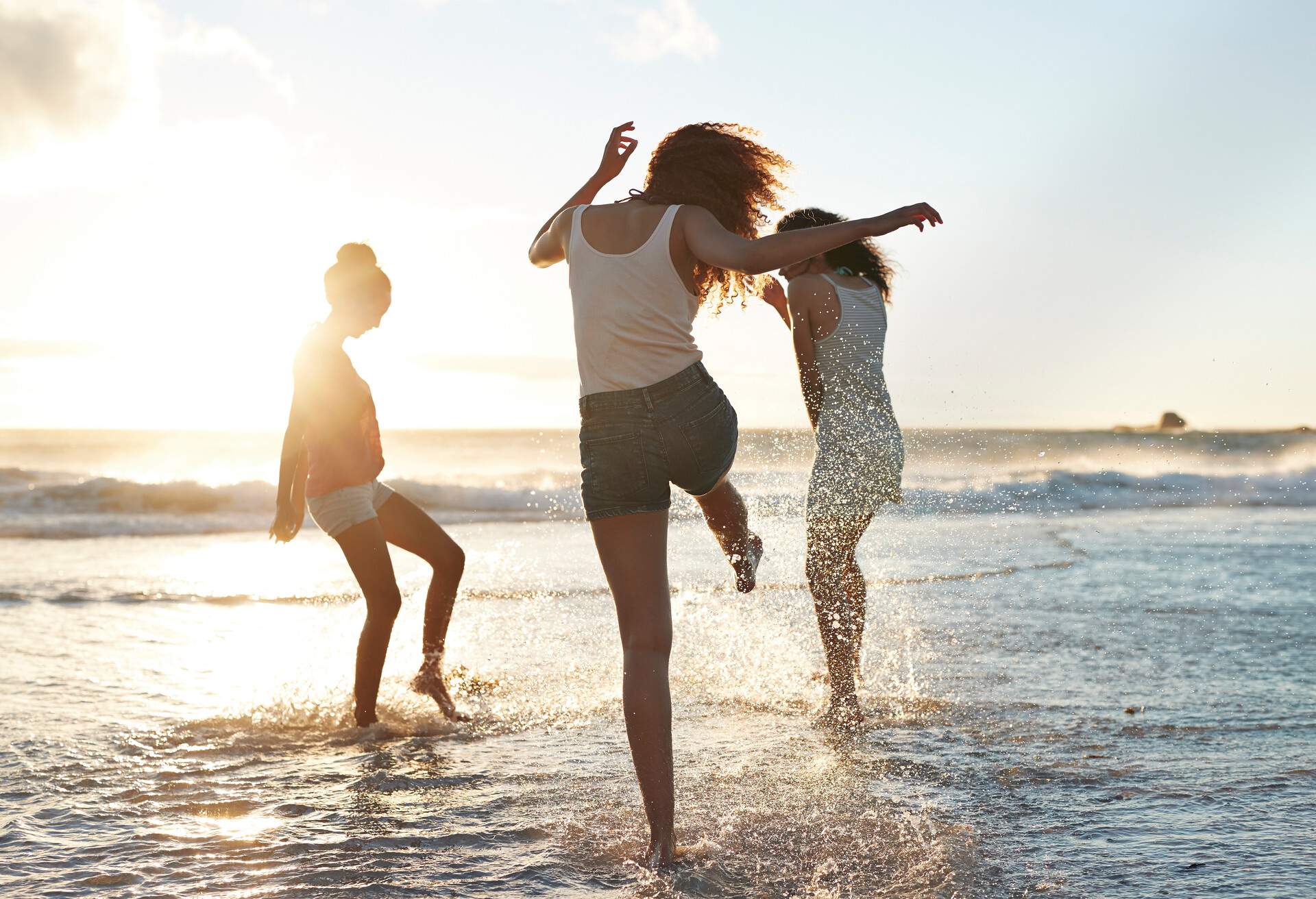 Young women hanging out at the beach, at sunset