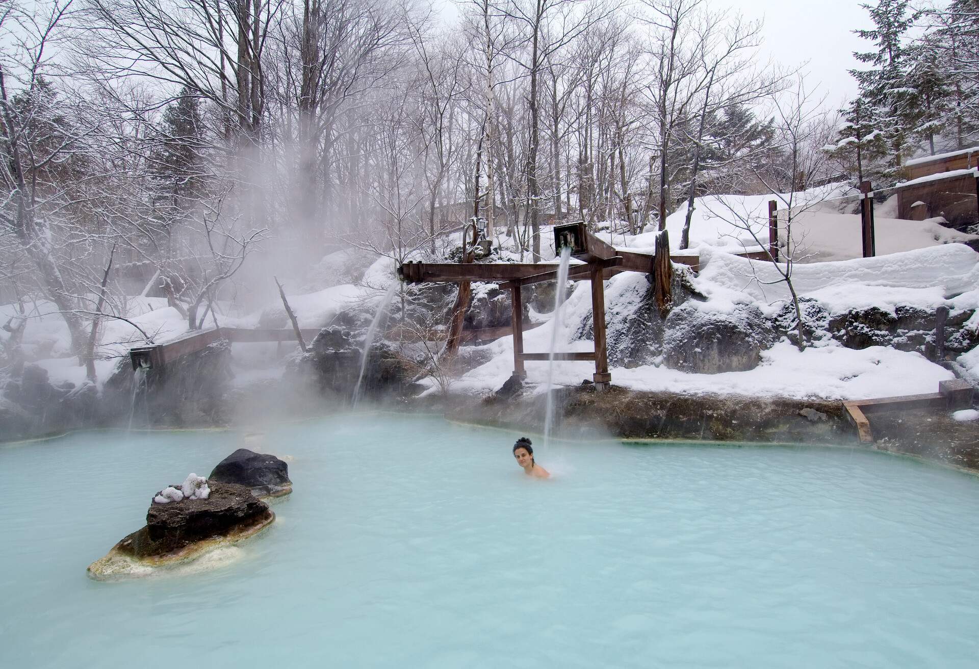 A caucasian woman have a bath in an open air hotspring, chubu region. japan.