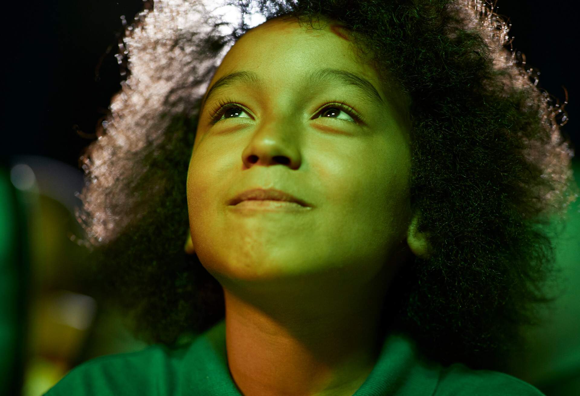 Curious boy with afro hair watching movie at theater