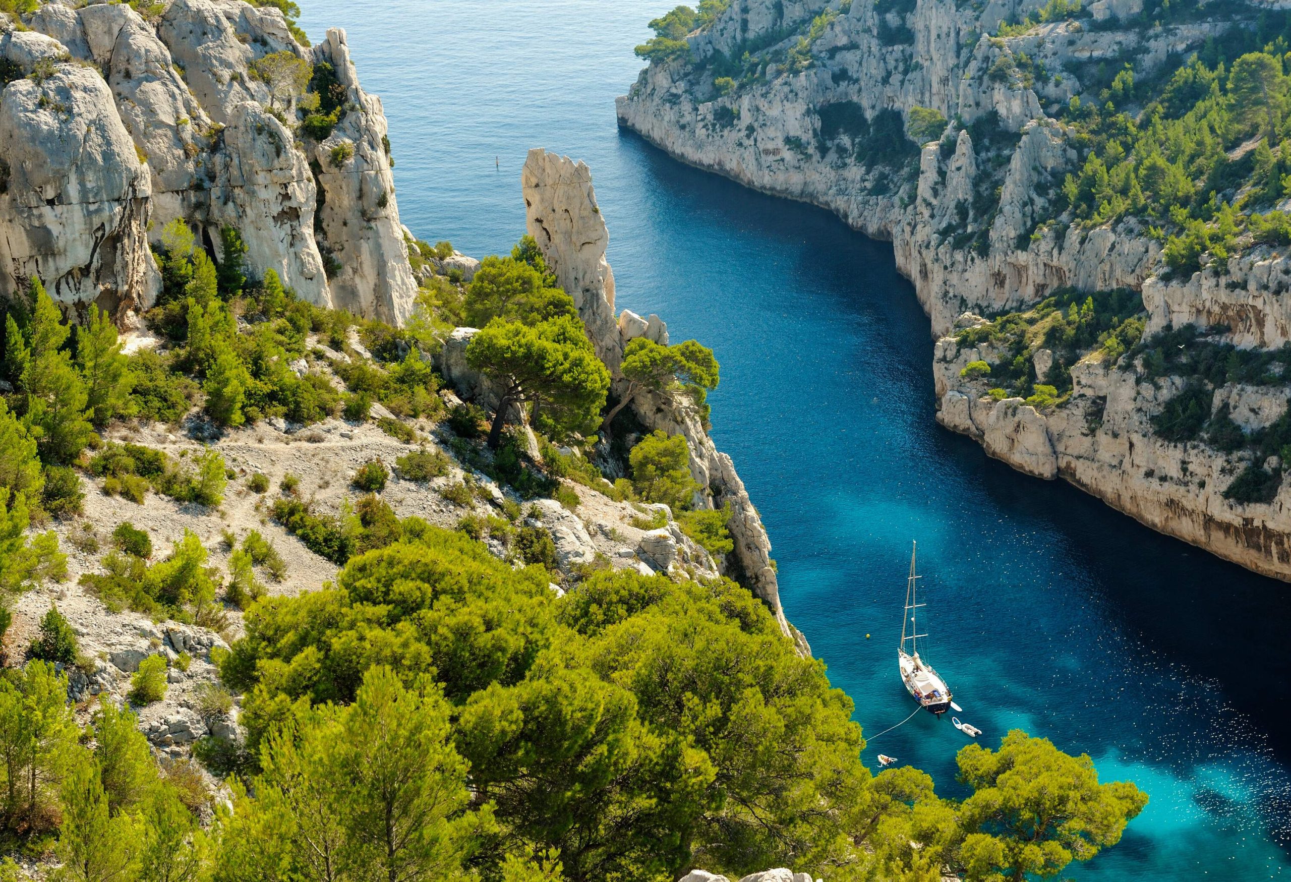 Aerial view of a calm blue ocean in the valley of lush crags.