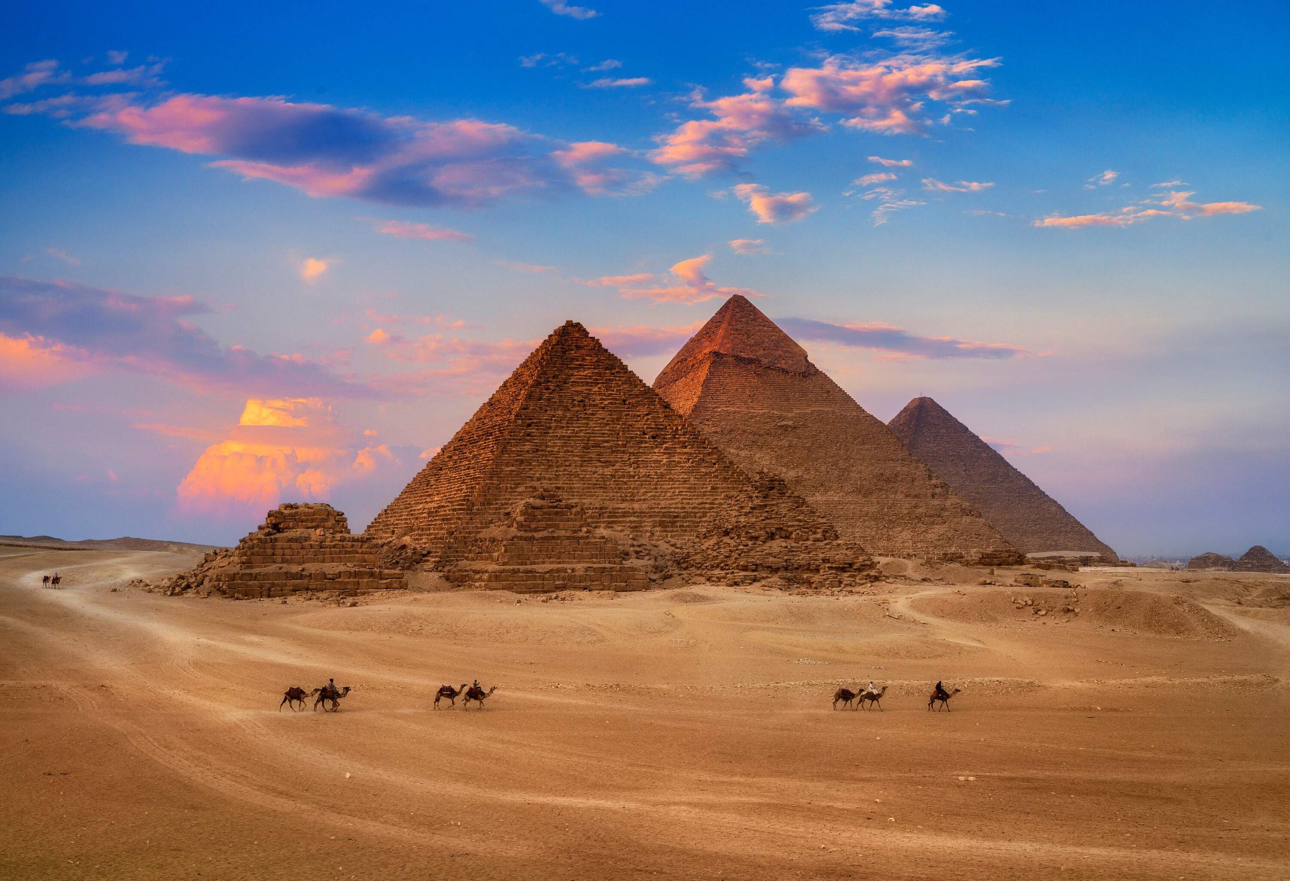 A picturesque view of the famous Giza Egypt Pyramids against the scenic sunset sky.