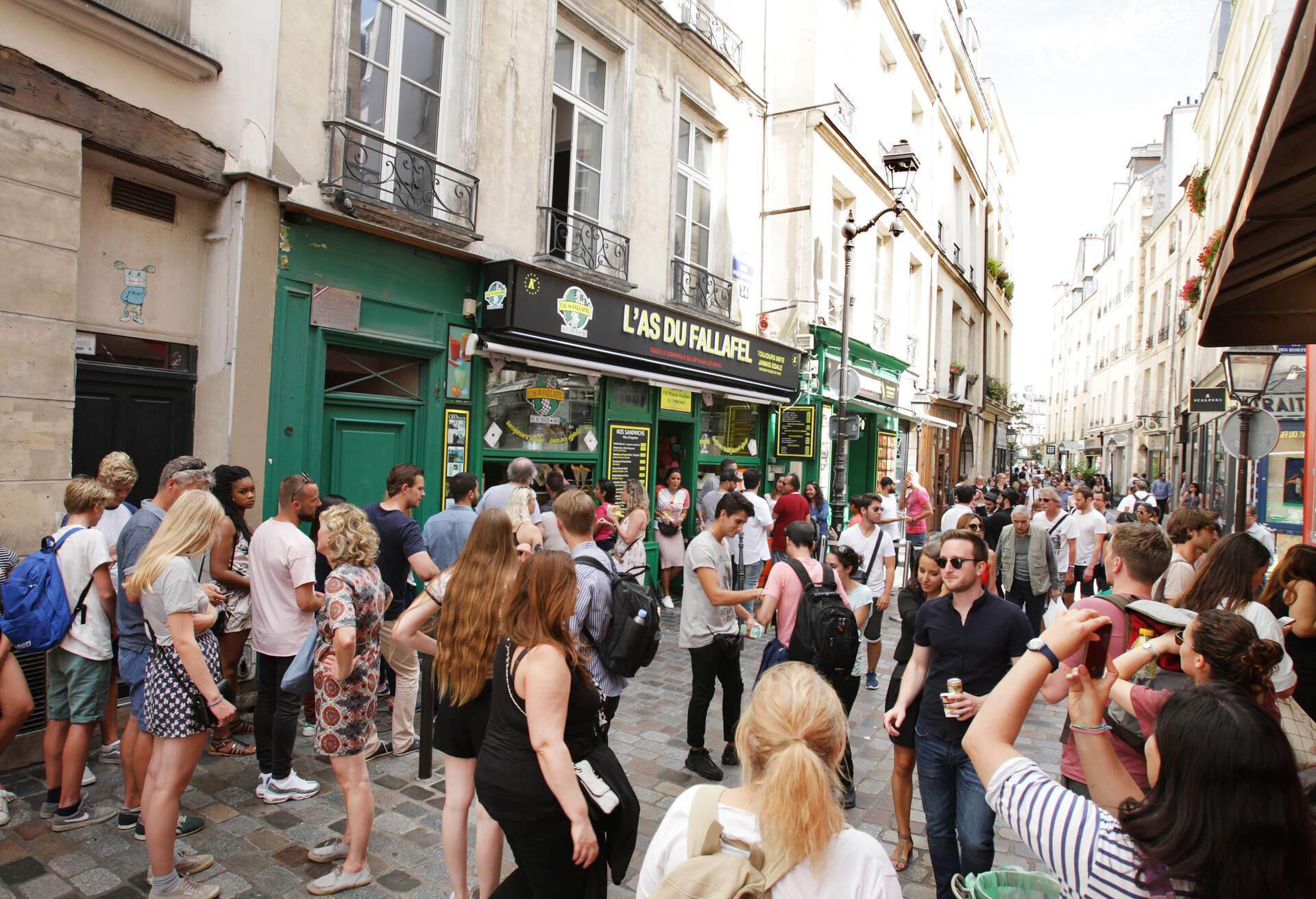 Tourists enjoying on the rue de Rosiers street in Le Marais district of Paris.