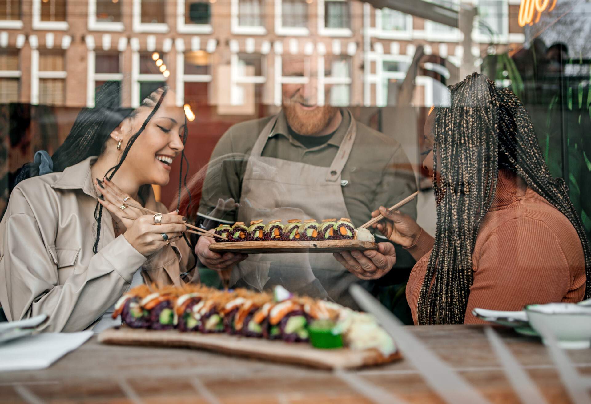 Friends enjoying sharing Vegan Sushi in a local restaurant