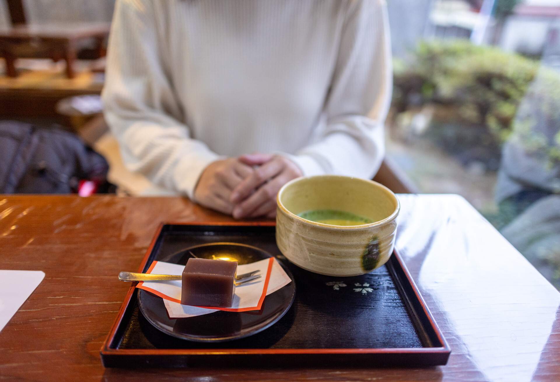 Woman sitting on tatami mat and ready to eat 'yokan' Japanese sweets and Matcha tea