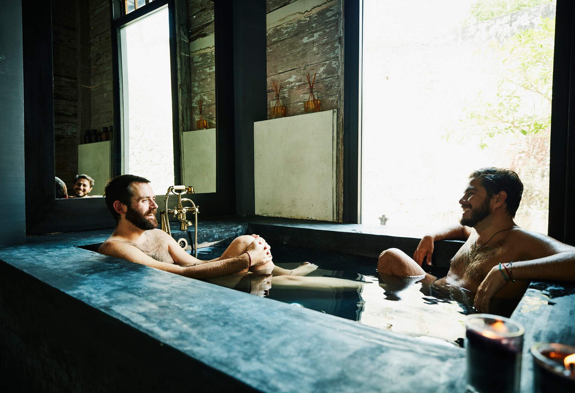 Two gay men relaxing in a hot tub.