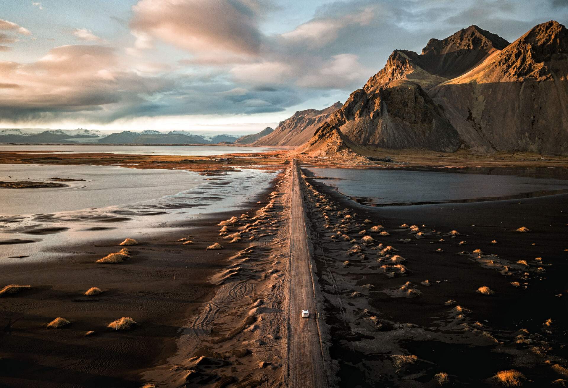 arial view of car driving along scenic road in iceland