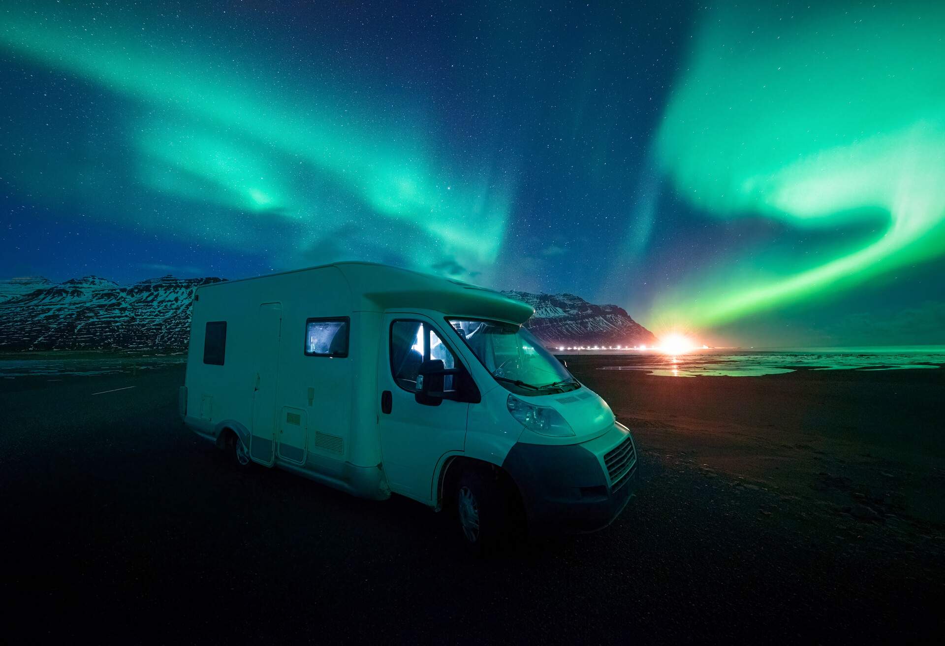 Aurora hunter with motorhome for mobility in the dark night sky under the spectacular celestial lights Aurora Borealis 