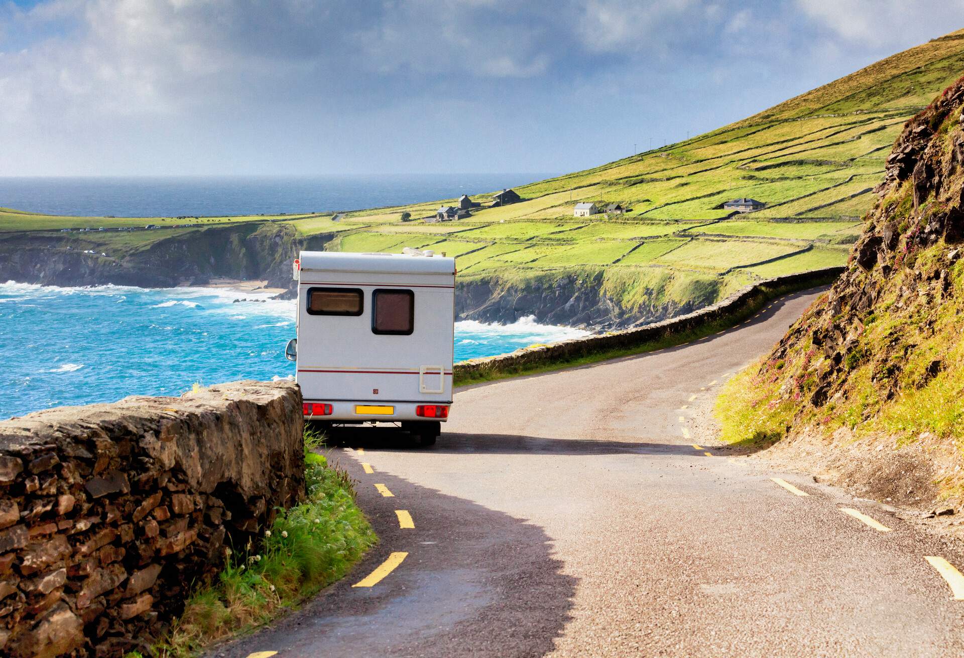 Campervan parked aside a desert road by the sea in Dingle peninsula 