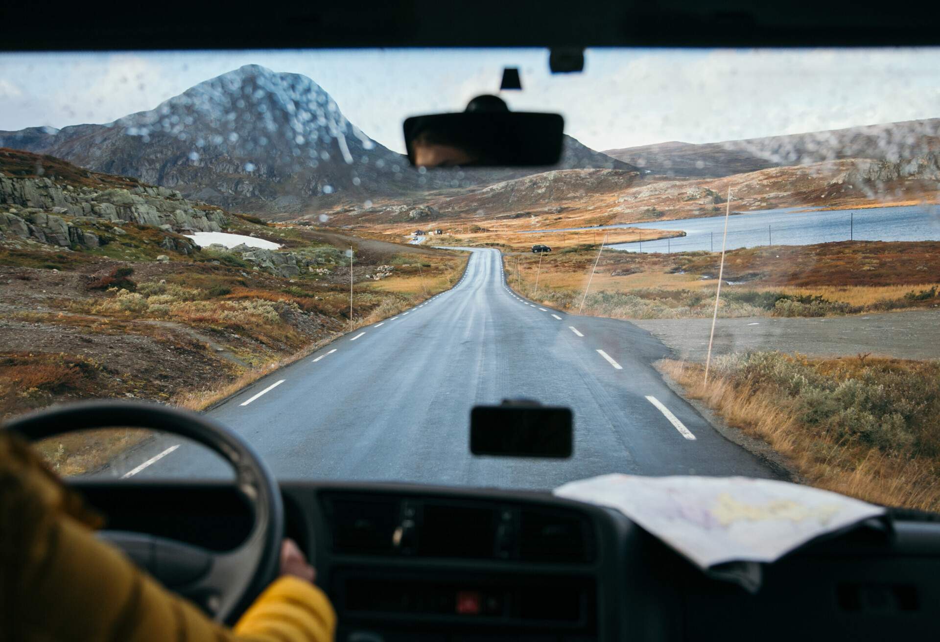 Focus on view from inside adventure car or camper van on amazing cinematic scandinavian landscape. Travel on epic road trip through mountains. Nomadic vanlife lifestyle. Life on the road 