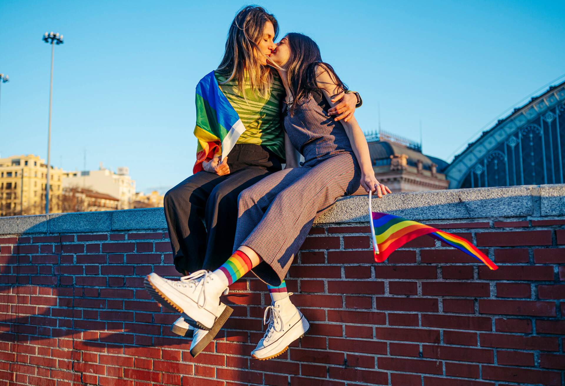 Couple LGBTQ with pride flag on the street of Madrid city, Spain