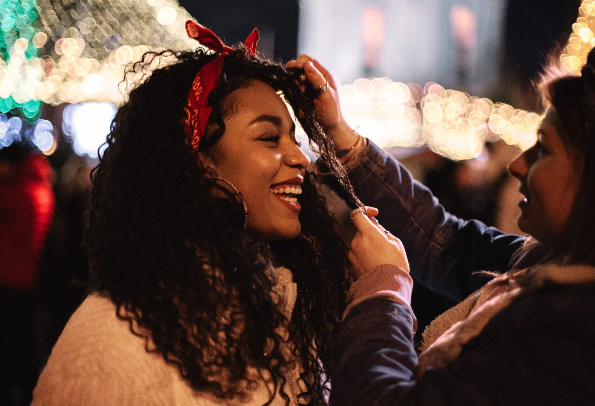 Jeune femme heureuse debout avec sa petite amie en ville pendant Noël.