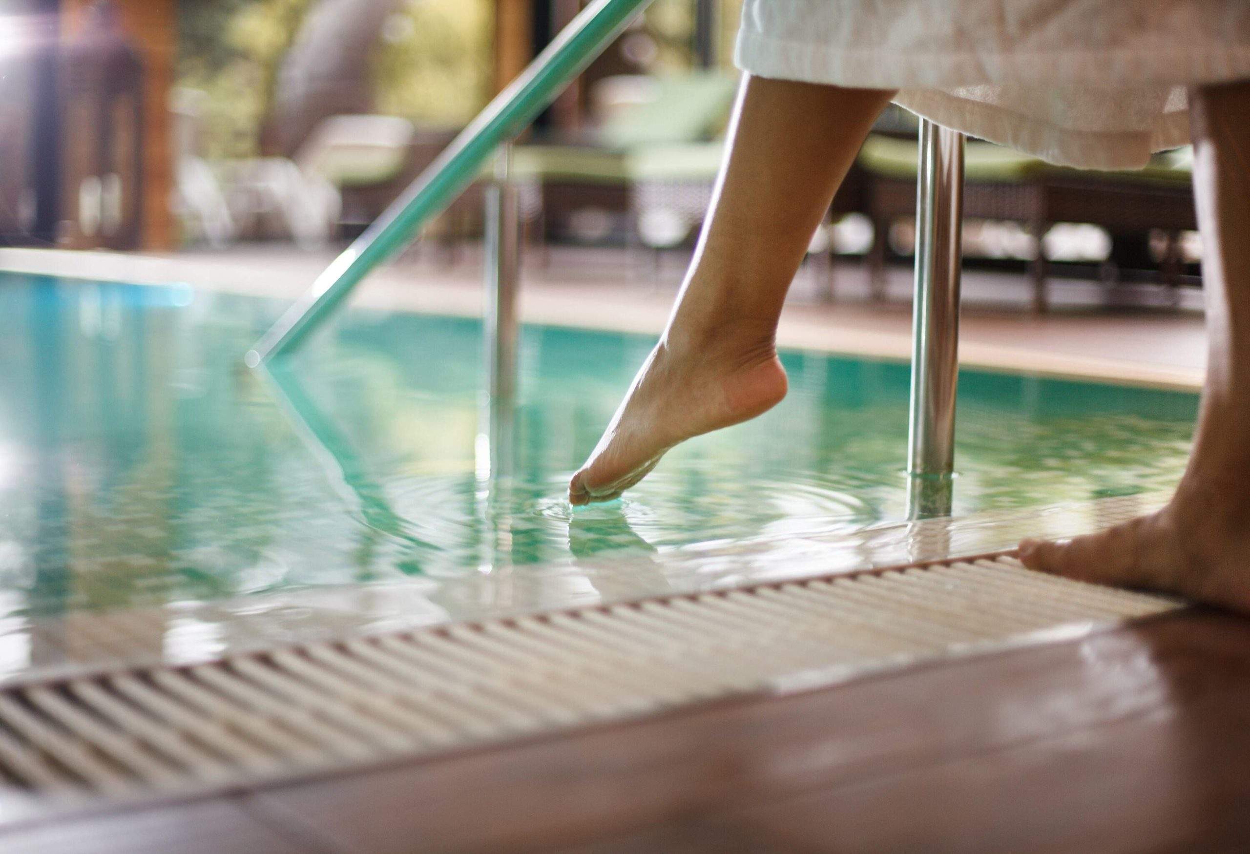 Une personne trempant son orteil dans une piscine.