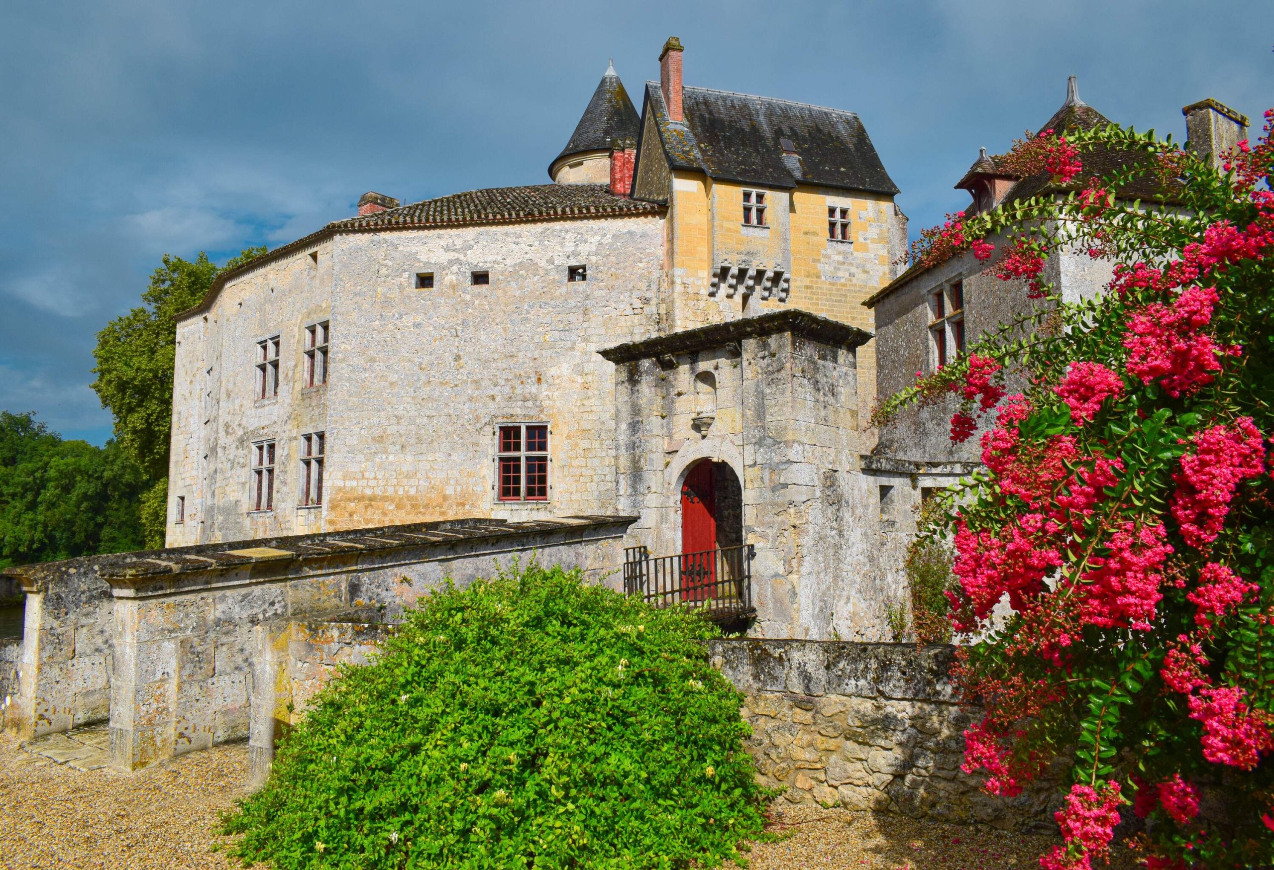 A historic building in the French Romanesque style that is adorned with colourful plants.