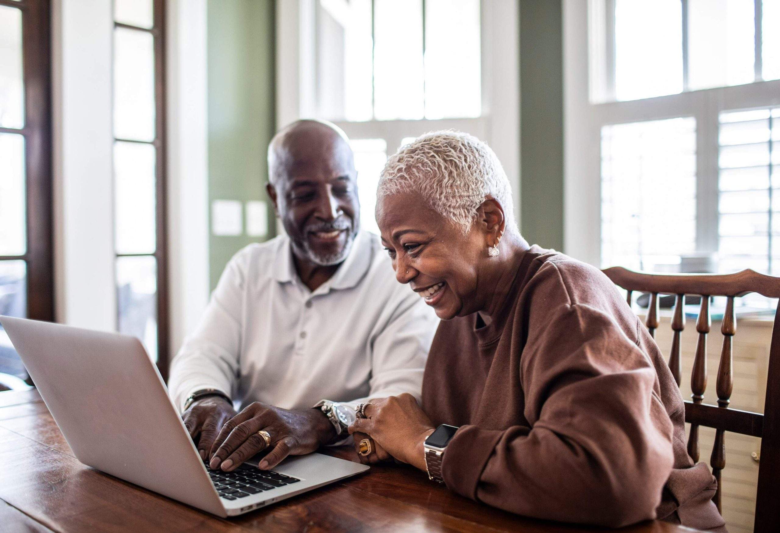 A couple smiling while looking at a computer