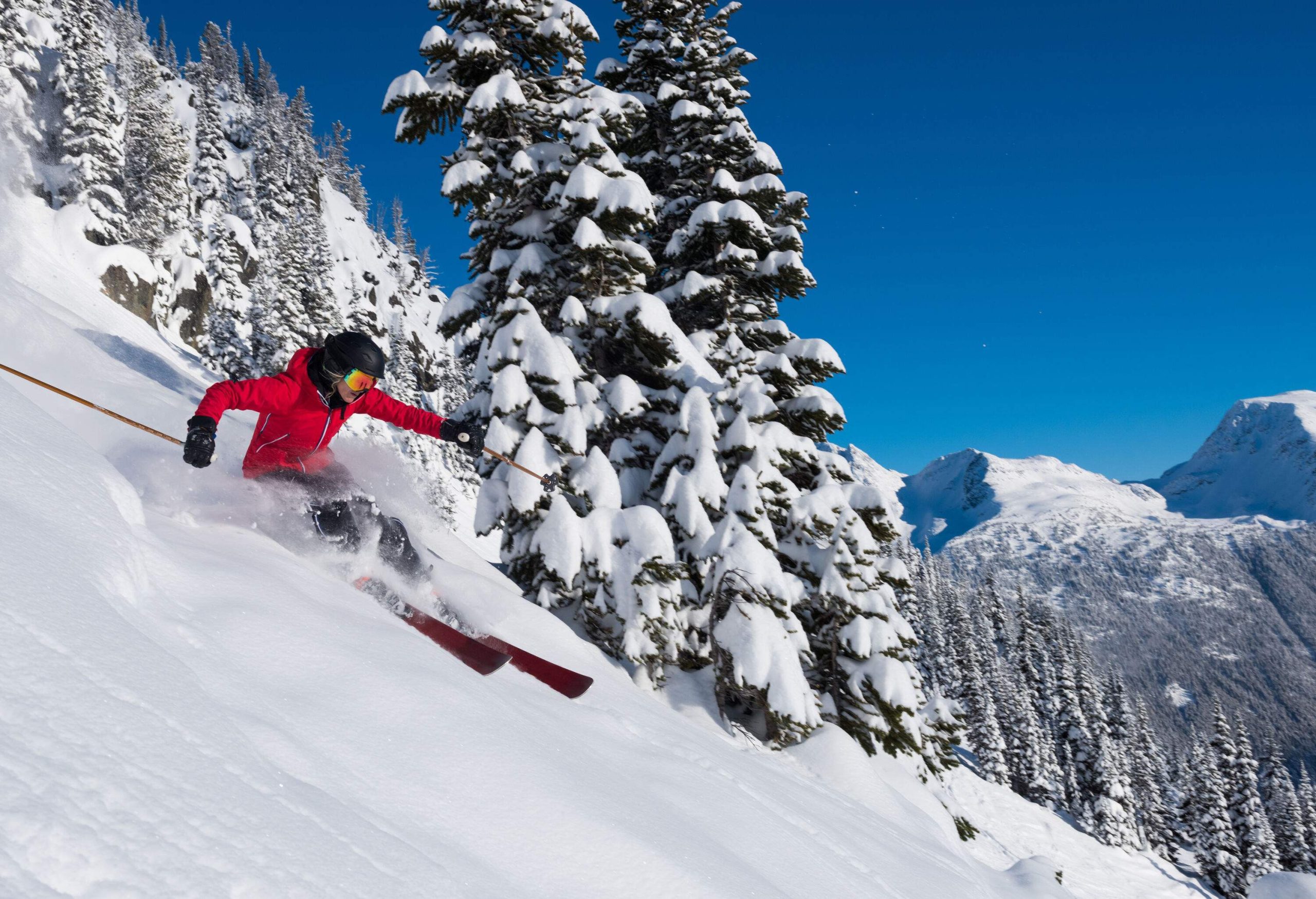 A female skier, skiing down the slope of snow covered mountain.