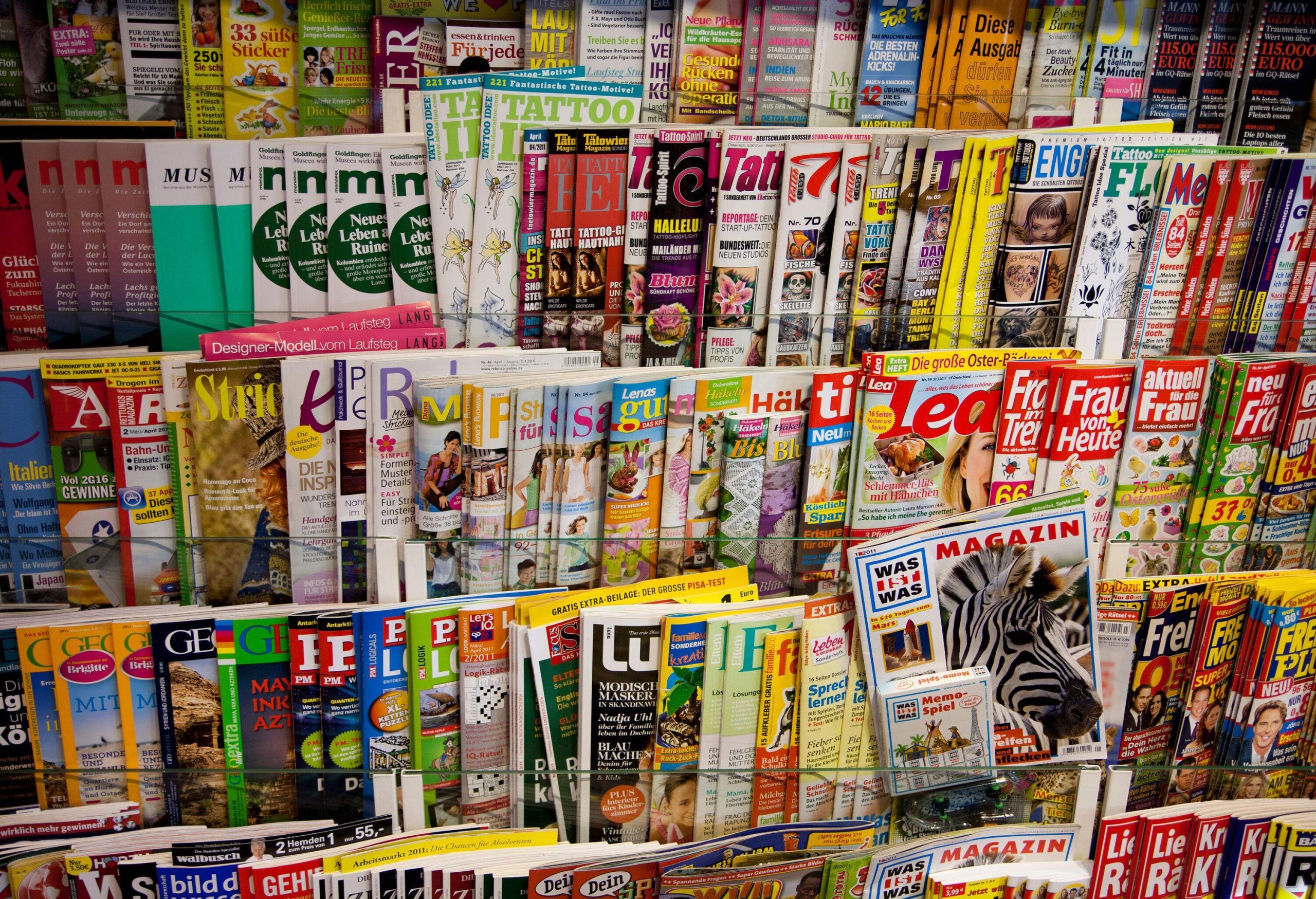 Racks of colourful magazines on a shelve.