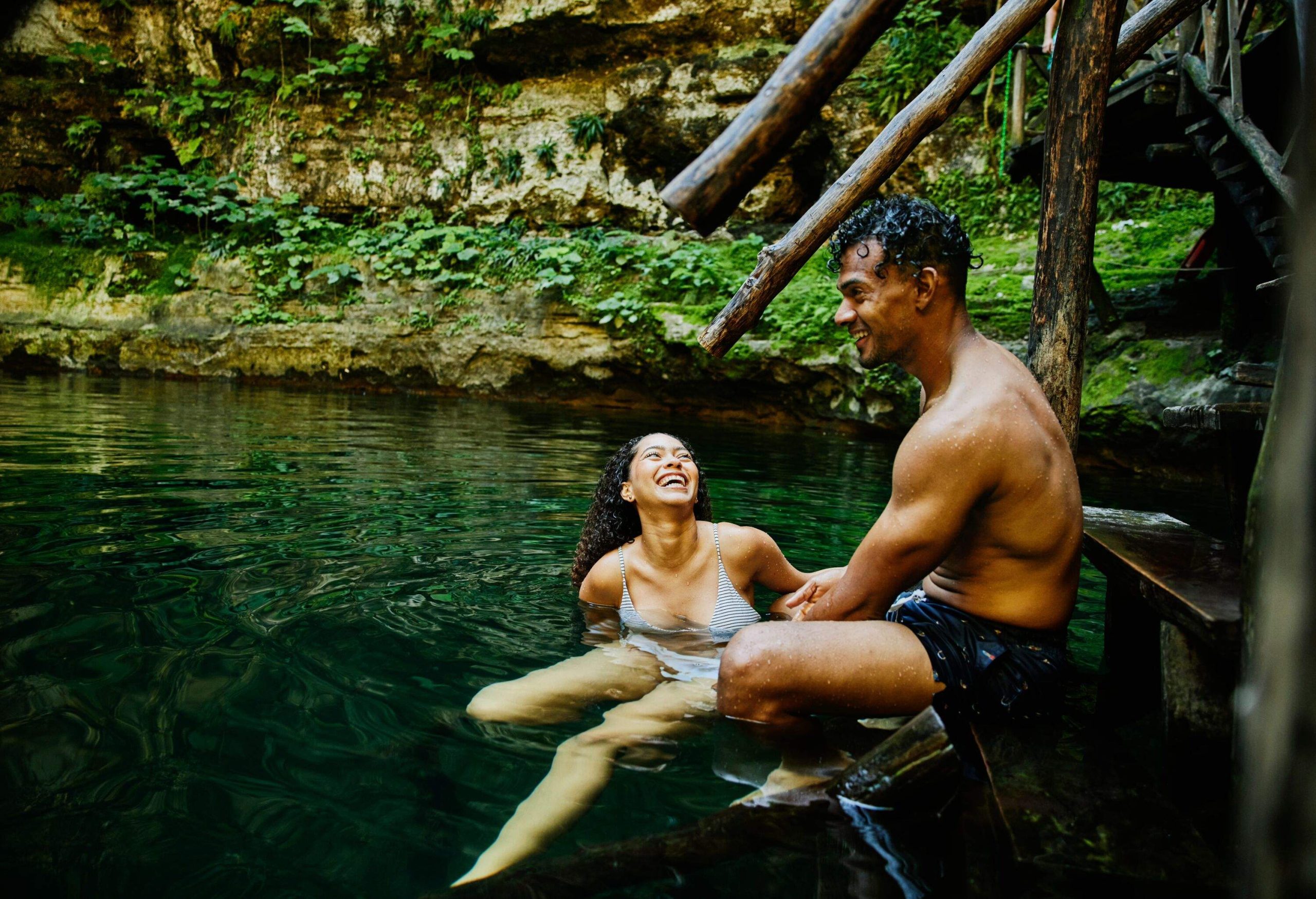 man and woman in the water in a cenote