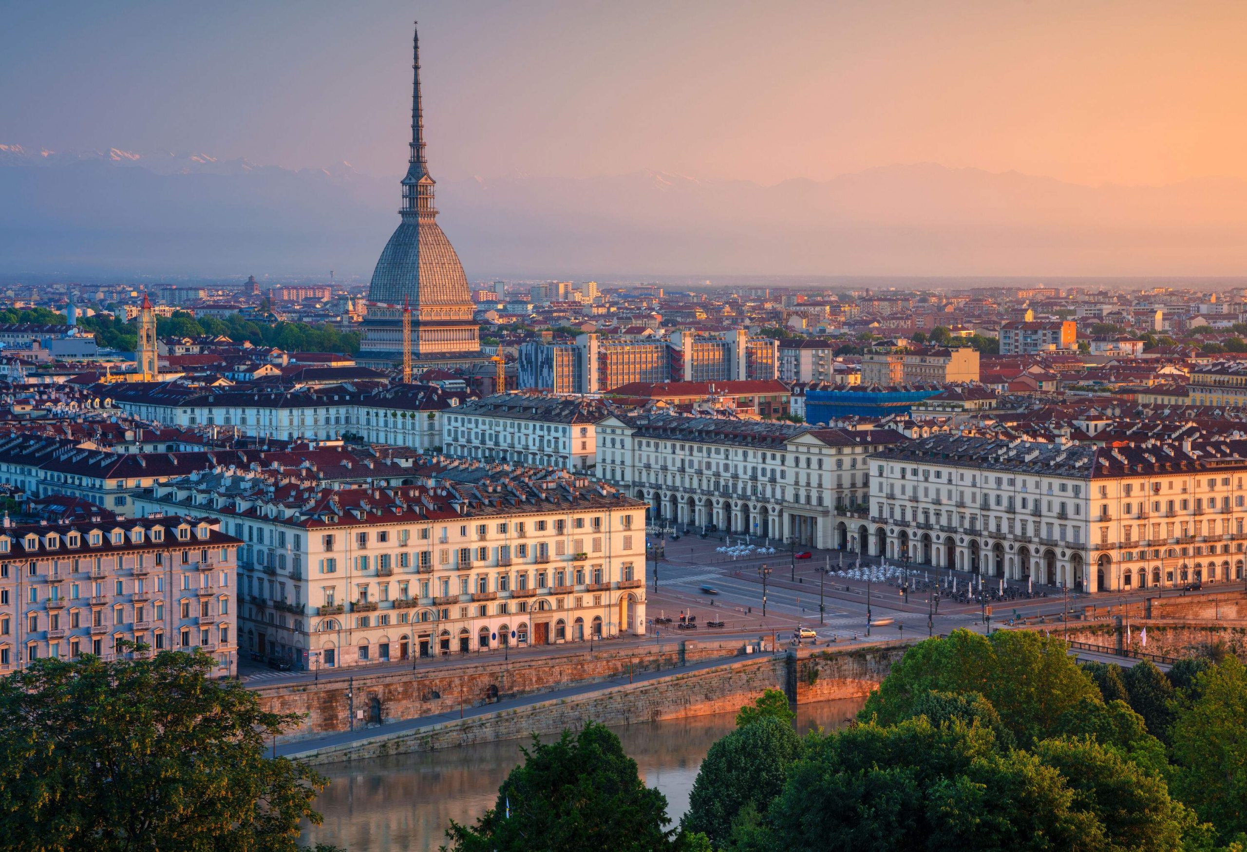 An imposing, monumental building with a spire stands out in the heart of a highly urbanised city.