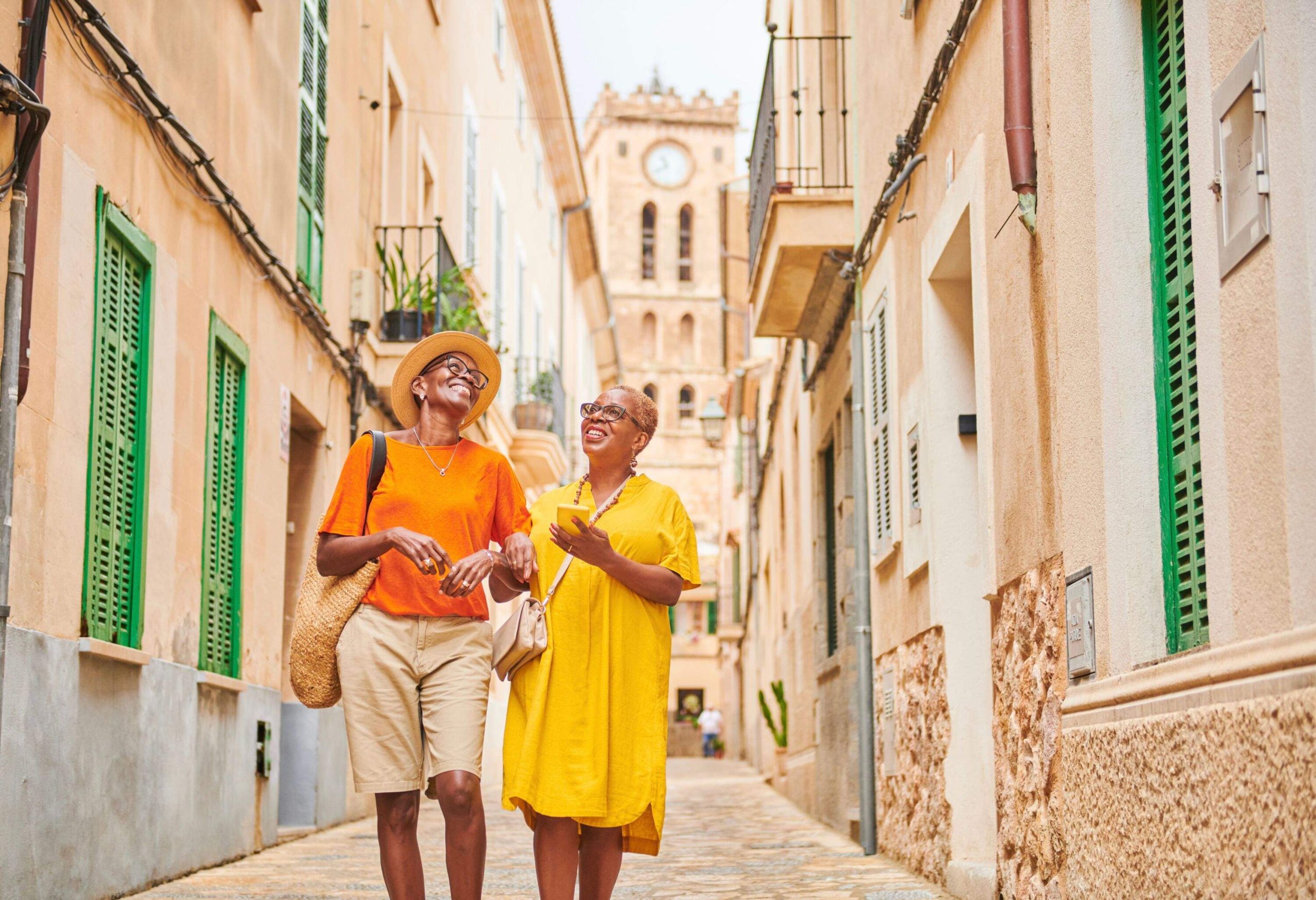 Using a mobile app on their smart phone to guide their way around a traditional old town in Majorca Spain.