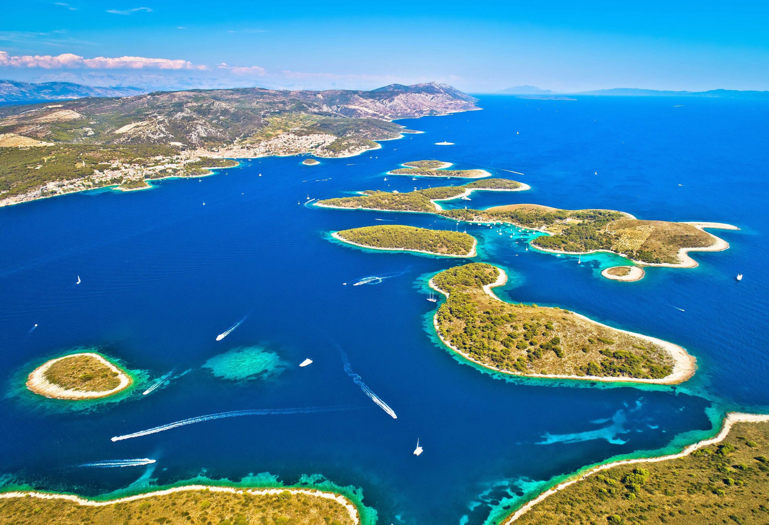 A group of small islands with white beaches scattered across a blue sea.