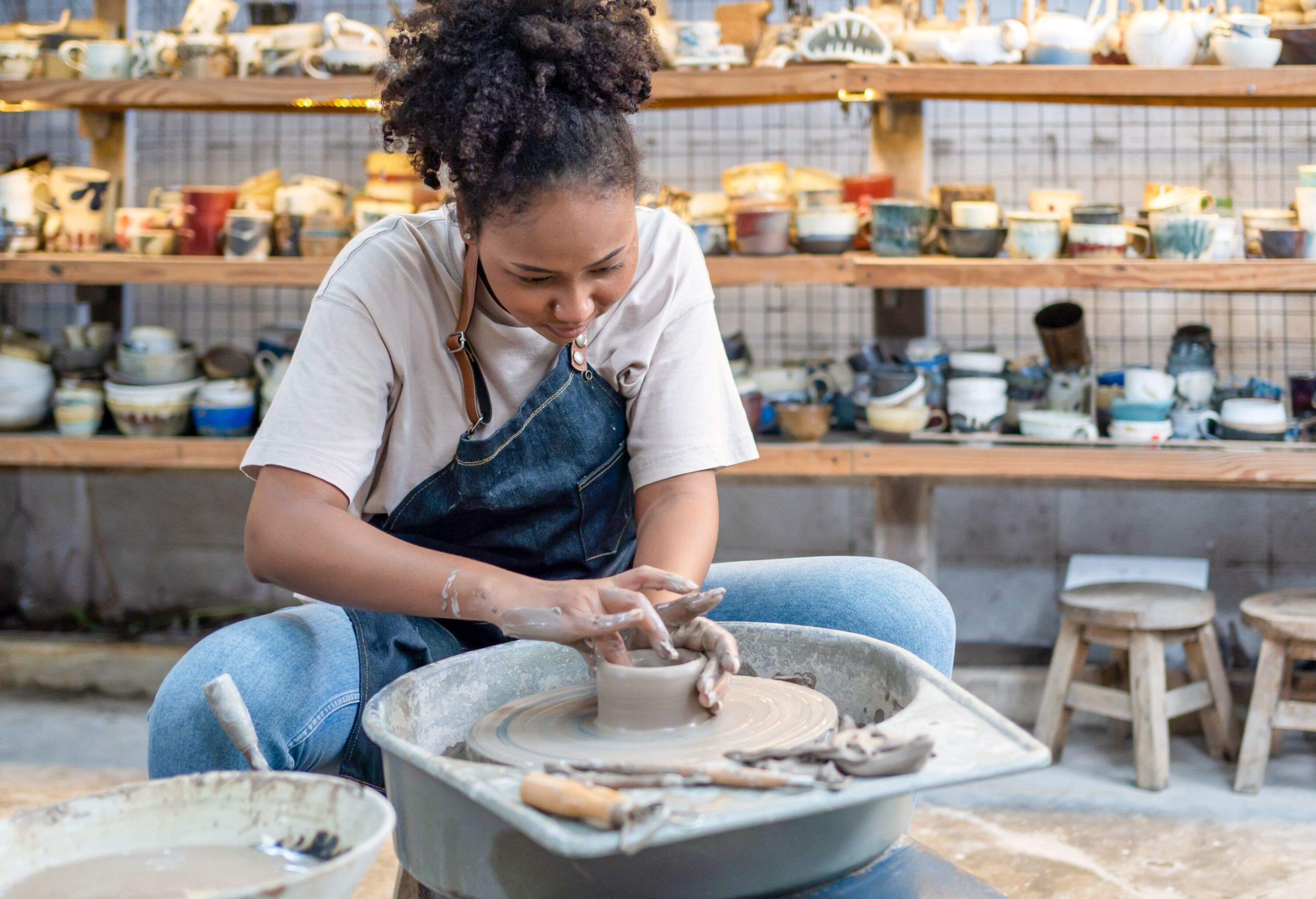Female potter working with clay on a pottery wheel.