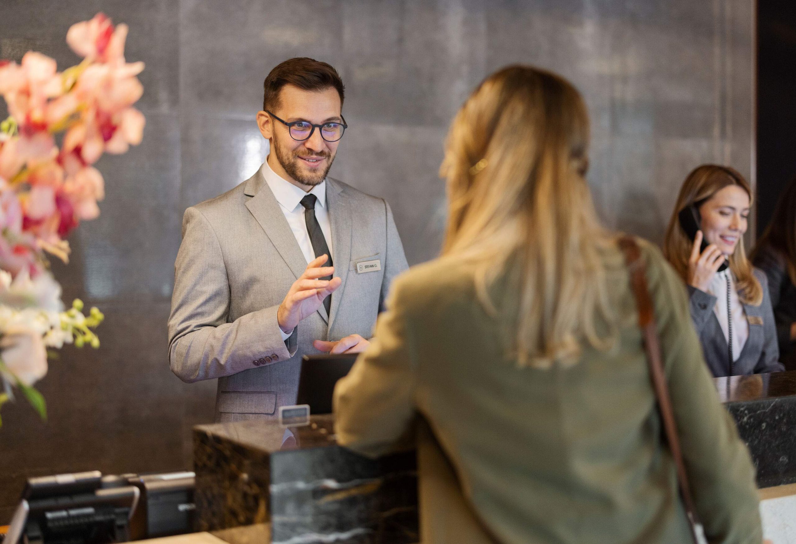 Male receptionist at front office talking with guest in hotel