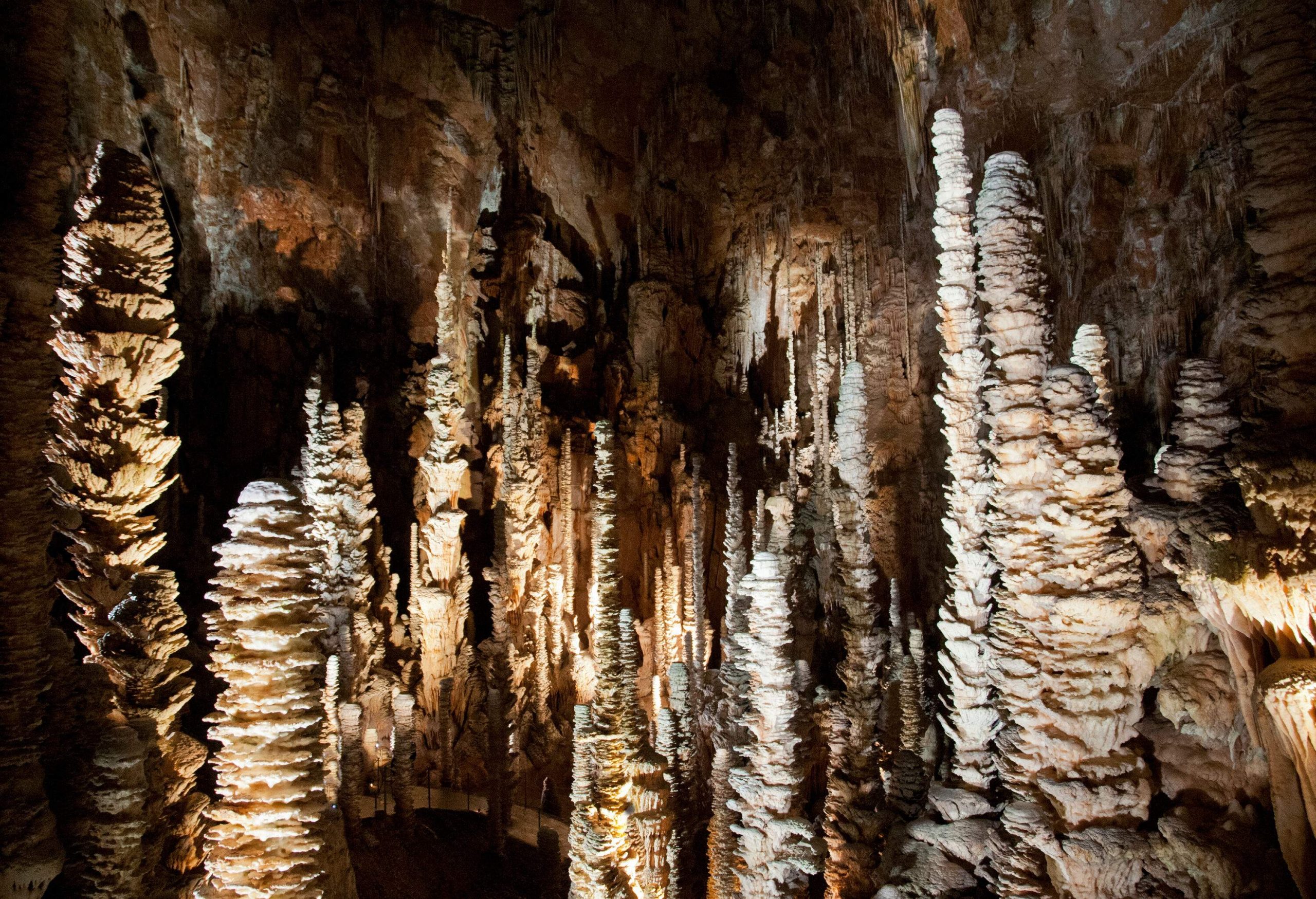 Illumination inside the cave reveals the varied heights of stalagmites and stalactites.