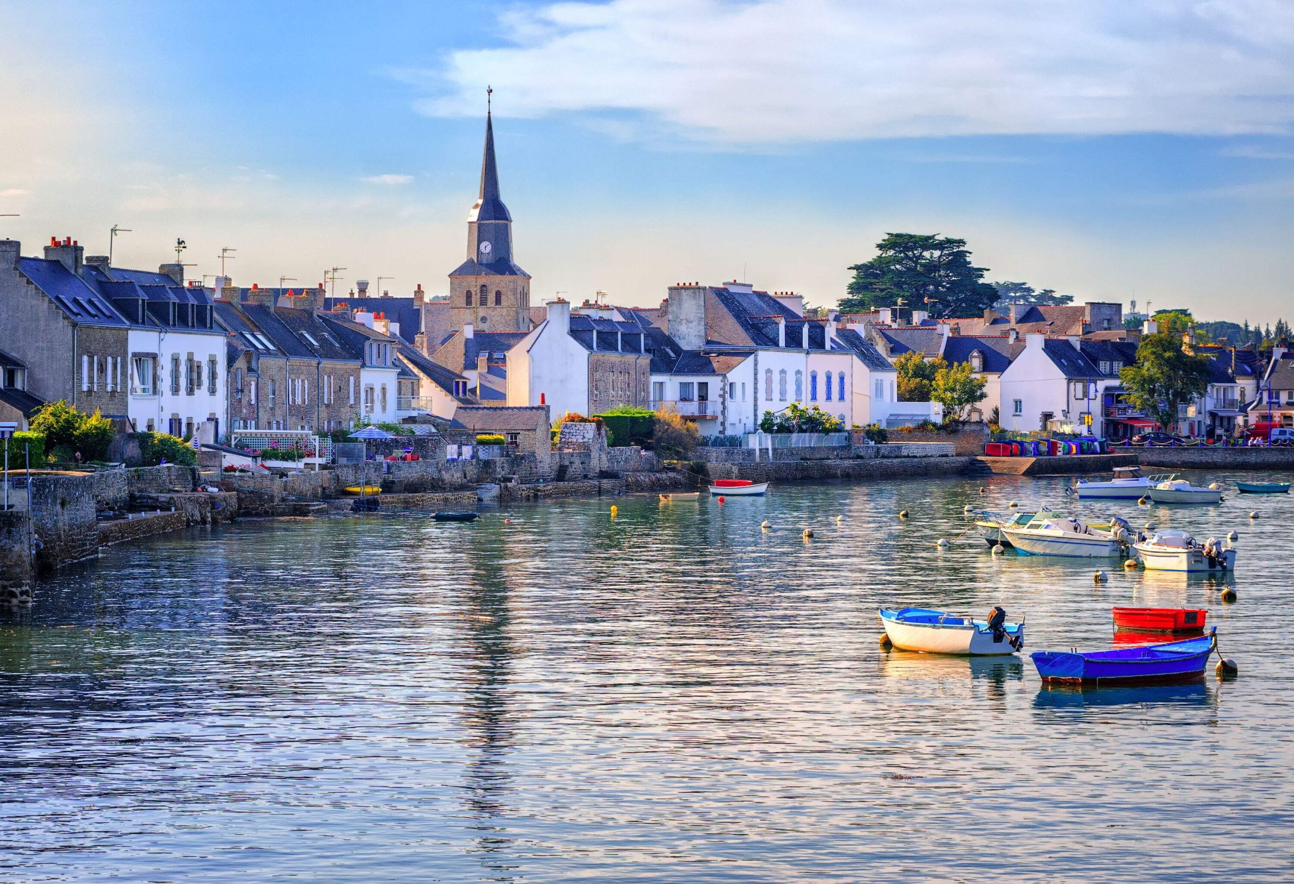 Row homes are situated on the bank close to a lake where unmanned boats are floating.