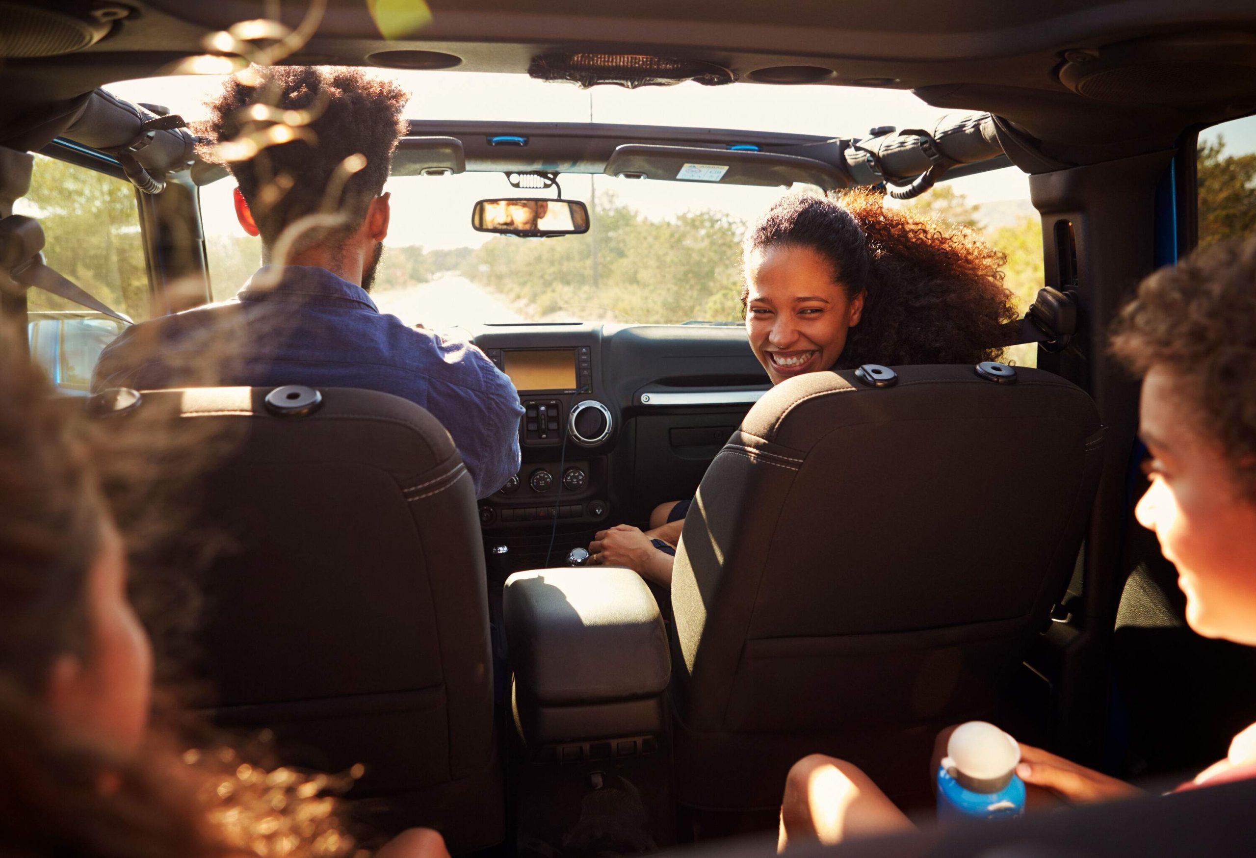 A family on a road trip with two kids in the backseat.