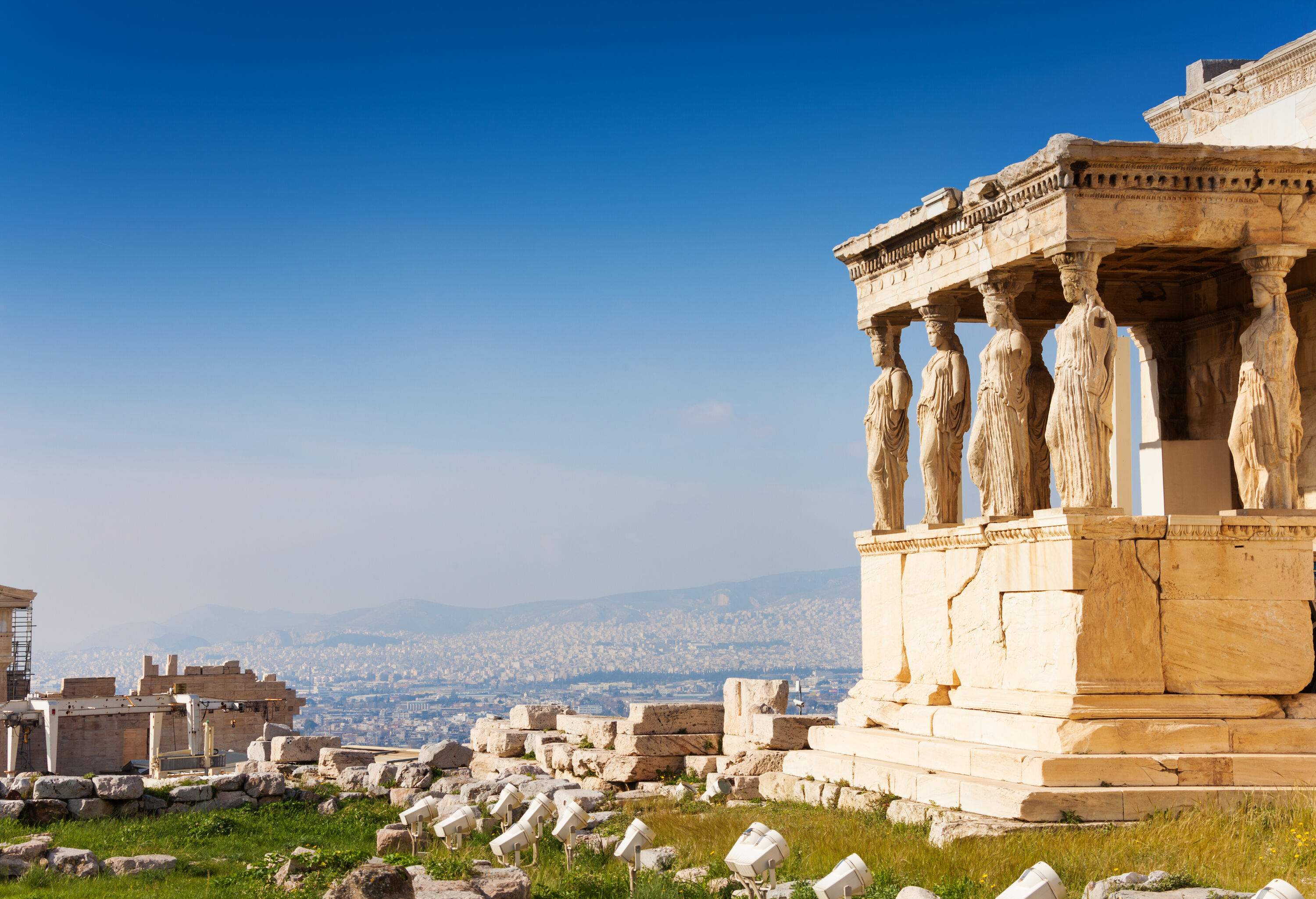 Porch of an ancient temple in an old ruined building on the Acropolis overlooking the cityscape of Athens.