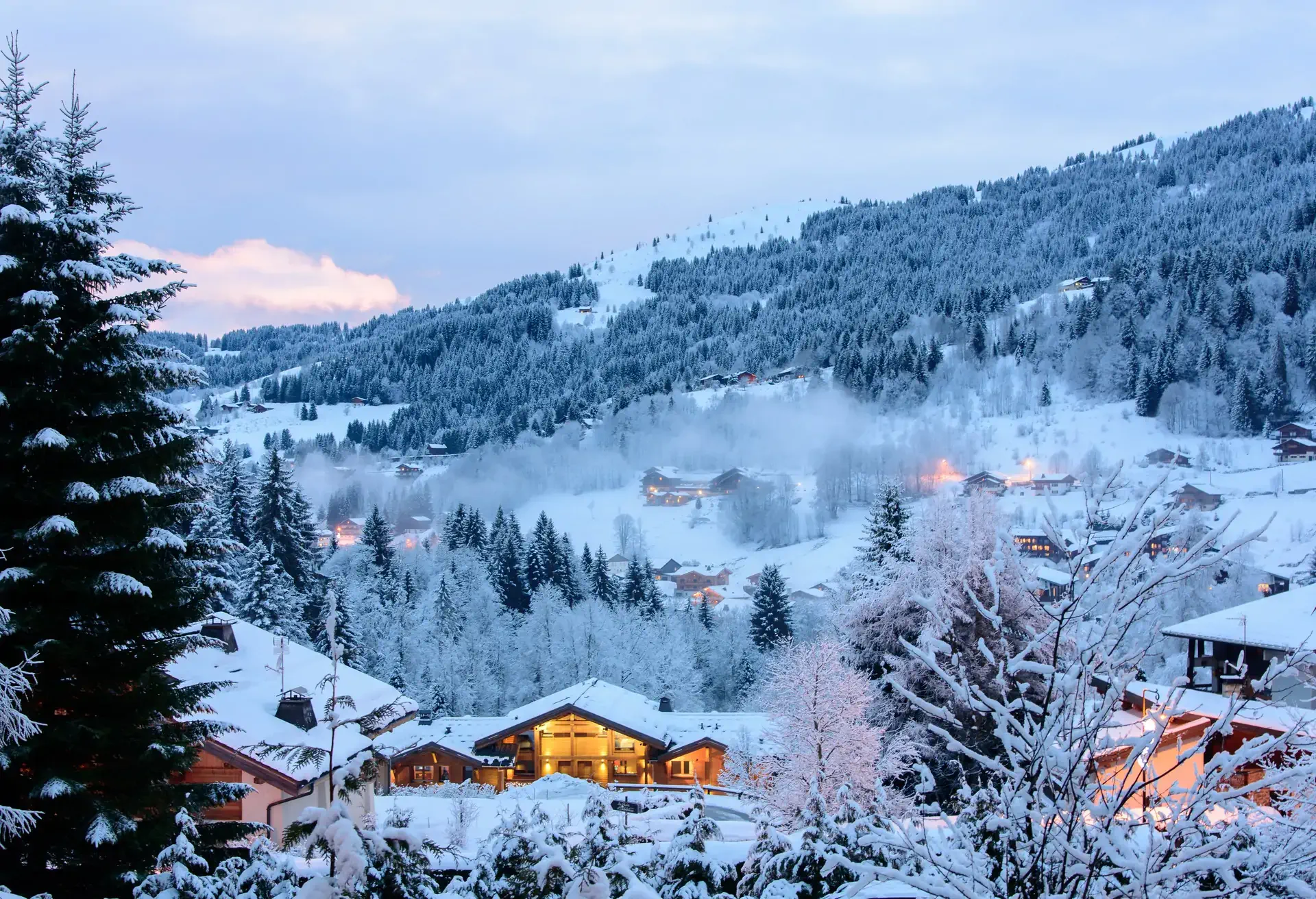 Winter evening view of a snowy valley with lit houses and cottages. Les Gets, France.; Shutterstock ID 387297649