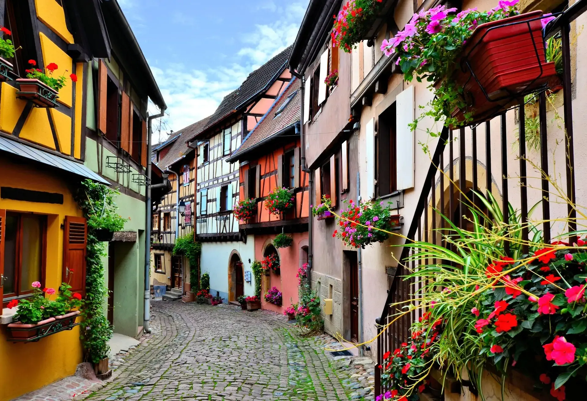 Quaint colorful cobblestone lane in the Alsatian town of Eguisheim, France