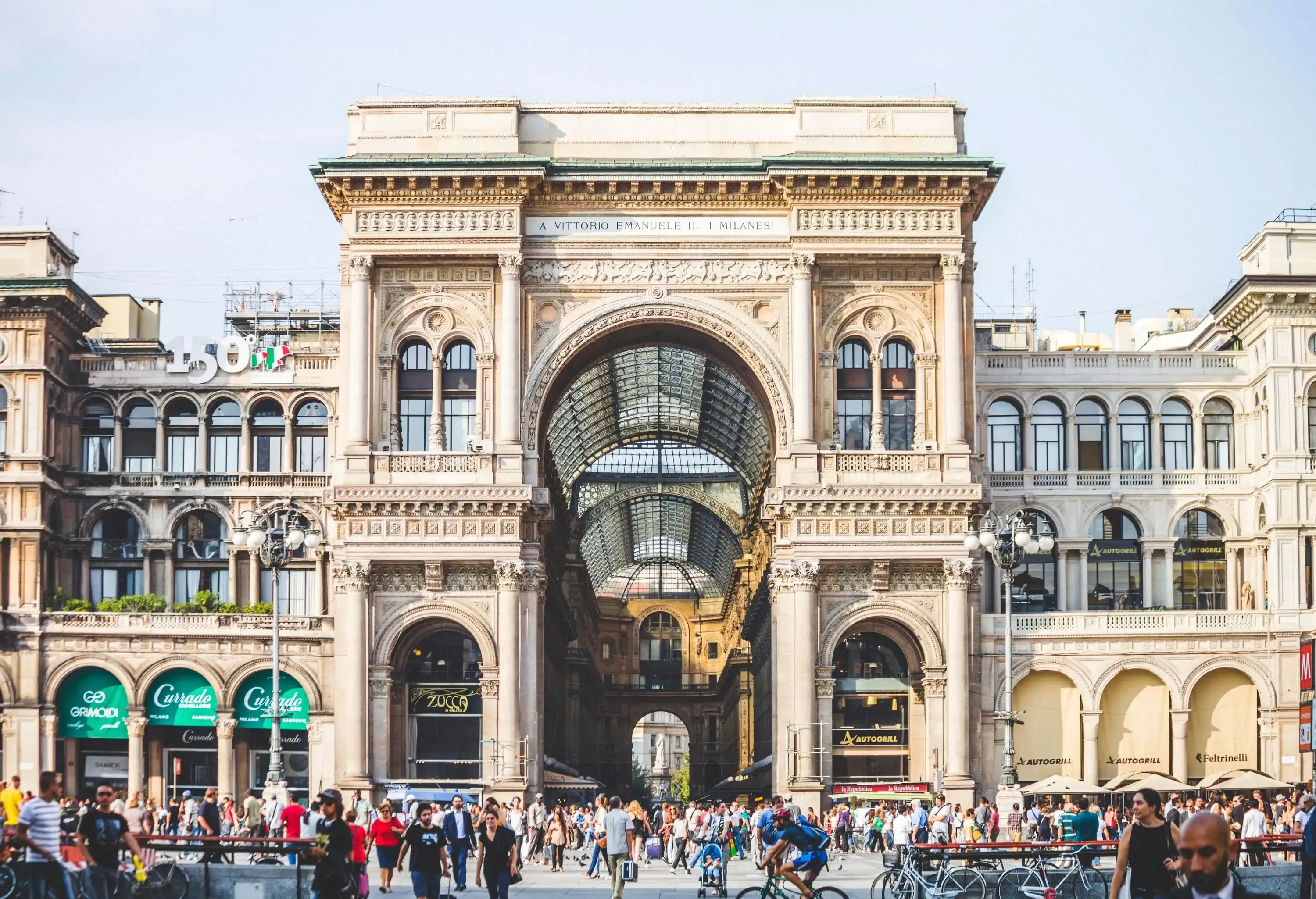 A bustling street with people strolling along the extravagant Galleria Vittorio Emanuele II.